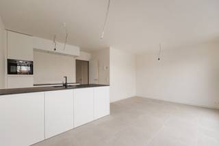 Dit recent opgeleverde appartement beschikt over een praktische indeling. Via de inkomhal met gastentoilet kom je terecht in de lichte leefruimte met open keuken. De moderne keuken is afgewerkt met een natuurstenen werkblad en volledig uitgerust met kwalitatieve toestellen, waaronder een inductiekookplaat, dampkap, oven, vaatwasmachine en ingebouwde koelkast. Vanuit de woonkamer heb je directe toegang tot het zonnige terras. Het appartement beschikt verder over 2 slaapkamers en een stijlvolle badkamer met lavabo en inloopdouche. Daarnaast is er een handige berging met aansluiting voor een wasmachine. Het appartement beschikt over een private berging in de kelder, ideaal voor extra stockage. Bovendien voldoet het appartement aan alle hedendaagse energienormen en is het voorzien van vloerverwarming, een warmtepomp, zonnepanelen, ventilatiesysteem C en regenwaterrecuperatie voor de toiletten en mogelijk ook de wasmachine. Zo geniet u van een energiezuinig en comfortabel woonklimaat. Op het gelijkvloers bevindt zich bovendien een praktische gemeenschappelijke berging voor fietsen en vuilnisbakken. Daarnaast is er de mogelijkheid tot het aankopen van een carport voor 20.000 euro (excl. kosten), alle voorzieningen voor een laadpaal zijn reeds voorzien. Extra troef: het verwachte E-peil bedraagt minder dan E10, wat recht geeft op een korting van 100% op de onroerende voorheffing gedurende 5 jaar. AANKOOP AAN 6% BTW MOGELIJK! Contacteer ons voor meer info op 03 568 03 03 of lauren@vastgoed03.be