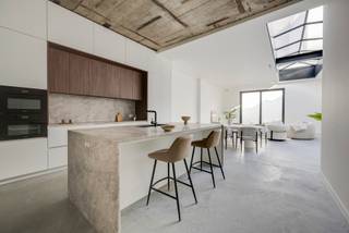 <p>Droom je van wonen op een absolute toplocatie? Ontdek deze indrukwekkende loft in de Begijnenstraat, ideaal gelegen tussen het bruisende Zuid, het gezellige Mechelseplein en de levendige Theaterbuurt. Hier woon je centraal, met tal van restaurants, cultuur en winkels op wandelafstand en openbaar vervoer vlakbij.</p>
<p>Deze exclusieve loft bevindt zich op het gelijkvloers van een recente, kleinschalige realisatie in een rustige achterbouw. Dankzij de indrukwekkende lichtstraat en de private tuin van ca. 79m² baadt de woning de hele dag in natuurlijk licht, een zeldzame troef in de stad.</p>
<p>De open, volledig uitgeruste keuken met elegant beige Emperador marmeren werkblad is voorzien van hoogwaardige toestellen van Miele: inductiekookplaat, combi-stoomoven, combi-microgolfoven, koelkast, vaatwasser en een stijlvolle winecooler.</p>
<p>De royale leefruimte met strakke betonvloer en grote raampartijen vormt het hart van de loft en sluit naadloos aan op de zonnige, uiterst rustige tuin met uitstekende privacy.</p>
<p>Verder beschikt de loft over een ruime masterbedroom met luxueuze ensuite badkamer met vrijstaand bad, ruime inloopdouche, dubbele lavabo en toilet. De tweede slaapkamer heeft eveneens een ensuite badkamer met inloopdouche en lavabo.</p>
<p>De vide met lager gelegen gedeelte zorgt voor een speelse indeling en is ideaal als bureau of lounge. Daarnaast is er een praktische berging met aansluiting voor wasmachine en droogkast.</p>
<p>Ruime inkomhal met mogelijkheid tot vestiaire en een apart gastentoilet.</p>
<p>Gemeenschappelijke fietsenstalling aanwezig.</p>
<p>EPB in opmaak.</p>
<p>Interesse? Contacteer LISTED voor een bezoek: +32 3 283 51 51.</p>
