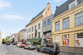 In de geliefde Nederstraat, op wandelafstand van de Grote Markt van Oudenaarde, bevindt zich dit uitzonderlijke handelshuis met een rijke geschiedenis en een unieke uitstraling. Het pand, momenteel gekend als Optiek Van de Velde, maakt deel uit van het beschermde erfgoed en staat geregistreerd als het prestigieuze Patriciërshuis. <strong>Vrij vanaf 1 augustus 2026.<br />Met een grondoppervlakte van 208 m² biedt dit karaktervolle gebouw tal van mogelijkheden voor handel, een combinatie van wonen en werken of een herbestemmingsproject, mits de nodige vergunningen. De handelsruimte op het gelijkvloers heeft een oppervlakte van ca. 143 m² en geniet van een uitstekende commerciële zichtbaarheid in één van de bekendste winkelstraten van</strong> de stad<strong>. Huurmogelijkheden: Enkel het handelsgelijkvloers: huurprijs € 1.495/maand. In dit geval is 2/3 van de onroerende voorheffing ten laste van de huurder.<br />Volledig gebouw (handelsgelijkvloers + bovenliggende verdiepingen): huurprijs € 1.895/maand. In dit geval is de volledige onroerende voorheffing ten laste van de huurder.</strong><br />De bovenliggende verdiepingen omvatten samen ongeveer 400 m² bruikbare oppervlakte en zijn bereikbaar via een afzonderlijke toegang, wat extra potentieel creëert voor diverse invullingen.<br />Het gebouw onderging recent omvangrijke restauratie- en renovatiewerken met respect voor zijn historische waarde. Zo werden de oude asbestleien en dakpannen volledig vervangen door hoogwaardige natuurleien in Maasdekking, werden nieuwe Velux-dakvlakvensters geplaatst en werd het dak geïsoleerd. Daarnaast werd de authentieke trapgevel vakkundig gerestaureerd, werd een belangrijke eiken zolderbalk hersteld en kreeg het oorspronkelijke gevelmetselwerk een grondige renovatie met veldsteen en kalkmortel, volledig in lijn met de erfgoedvereisten. De uitvoering van deze werken startte in de zomer van 2024 CV op aardgas. Afzonderlijke meters voor het appartement en het commercieel gelijkvloers.<br />Een zeldzame opportuniteit voor ondernemers of liefhebbers van historisch vastgoed die op zoek zijn naar een prestigieus pand met uitstraling, ruimte en een uitstekende ligging in het historische stadscentrum van Oudenaarde. Meer informatie of een bezoek ter plaatse? Contacteer ons voor een persoonlijke rondleiding door dit unieke erfgoedpand.