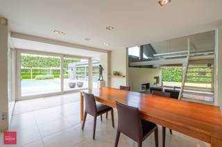 Afgeschermd van straatbeeld en met toegangsdreef bereikbaar. Ruime tijdloos hernieuwde villa (462m² vloeroppervlakte) bestaande uit een inkomhall, living met open haard, ingerichte keuken (Fraeye), eetruimte, annex berging met toegang tot mooie kelder en zolder, 3 slaapkamers (1 beneden), badkamer en bureel op verdieping. Aangesloten uitbouw met hoofdslaapkamer / dressing, / badkamer, leefruimte met open haard, sauna, ontspanningsruimte, technische ruimte. Garage voor 2 wagens, carport met tuinberging en parking. Zwembad (Bob Monteyne) met buitendouche. Alle modern comfort (vloerverwarming, 59m² zonnepanelen met groenestroomcertificaten tot 2032, 20.000 l regenwater etc)