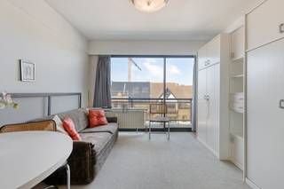 This bright studio is located in the'T HOGE residence (built in 1976) at a central location on the Zeelaan in Koksijde. Due to its convenient location, you are surrounded by shops, restaurants and public transport, while the sea and dunes are also a short distance away. This makes the studio ideal as a compact main residence or as a comfortable second home.<br /><br />Inside, the entrance hall connects the various functional areas. The living space enjoys plenty of light and offers direct access to the sun-facing terrace. The studio also has a kitchen with basic amenities and a bathroom equipped with a shower and a sink. The listed sales price also includes a private storage room and a private parking space.<br /><br />Looking for interesting real estate opportunities in Koksijde? Be sure to read on!<br /><br />LAYOUT<br />> Fifth floor:<br />- Living room with open kitchen and access to the sun-facing terrace<br />- Bathroom with shower, sink and toilet<br /><br />GENERAL:<br />- Private basement storage included in the price<br />- Private parking space included in the price<br />- Common bicycle shed available<br /><br />Are you looking for an apartment as a permanent home, investment or second home? Do not hesitate to contact the file manager Yari Devos at 0491 27 21 85 or yari.devos@dewaele.com.<br /><br />Register of measures: no
