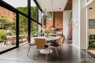 Quares - TREVI Groep presenteert :<br />Deze eigenzinnige woning is ontstaan uit een herenhuis, versmolten met een nieuwbouwwoning. U geniet dus van de prachtige stijl van een herenhuis in het comfort en ruimtelijkheid van een nieuwbouw, met grote glaspartijen, veel lichtinval en een zeer ruime tuin. <br /><br />U komt binnen via de oude woning met prachtige authentieke elementen en geniet onmiddellijk van het comfort van de nieuwbouwwoning met zeer hoge plafonds en een grote raampartij die rechtstreeks uitkomt op de tuin. De breedte van de tuin is 11 meter, ingericht in Piet Oudolfstijl, waardoor je midden in de stad kan genieten van een eigentijdse oase van groen. <br /><br />Omdat de woning meer dan 500m² omvat beschikt u over een grote leefruimte met geïnstalleerde keuken, aangrenzend aan de tuin. Via zwevende betonnen treden komt u in de living. In dit (nieuwbouw) gedeelte van de woning vindt u ook nog drie slaapkamers en een badkamer en dressing. Naast de keuken bevindt zich een grote garage (40m²). Als je in de inkomhal de trap omhoog neemt, komt u in een apart gedeelte van de woning met nog eens vier slaapkamers, twee badkamers, een leefruimte met keuken en een dakterras met prachtig zicht op de stad, dit gedeelte staat volledig los van de andere delen van de woning en wordt momenteel in co-housing gebruikt. De woning is ontworpen door de architecten 'Verdickt & Verdickt '.Ideaal als praktijk of kantoorruimte. <br /><br />De omgeving van de Oude Steenweg bevindt zich in een stukje Antwerpen in volle ontwikkeling, vlakbij de Paardenmarkt via waar je op wandelafstand bent van zowel het toeristische centrum als het bruisende Eilandje. De wijk Dam met park Spoor Noord en de vernieuwde slachthuissite bevindt zich ook op wandelafstand. Aan de woning zelf zijn er volop winkels en openbaar vervoer.
