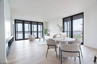 <h3>Exclusief wonen aan de Scheldekaaien met royale buitenruimtes</h3>
<p>Droomt u van een instapklaar, luxueus appartement op het bruisende Nieuw Zuid?<br />Dan zal deze parel met zicht op de Schelde u zeker weten te bekoren.</p>
<p><strong>Duurzaam, groen en stedelijk wonen</strong> – dat is waar de nieuwe wijk Nieuw Zuid in Antwerpen voor staat.</p>
<p>Op de vierde verdieping van de stijlvolle residentie <em>Zuiderhuis</em> ontdekt u een uitzonderlijk woonconcept dat elegantie en comfort combineert.</p>
<p>Wat dit appartement zo bijzonder maakt?<br />De prachtige wintertuin die grenst aan zowel de leefruimte als de slaapkamers. Deze ruimte vormt een natuurlijke verlenging van het interieur en laat u het hele jaar door genieten van licht, lucht en uitzicht. Vanaf het ruime terras geniet u van onvergetelijke zonsondergangen over de Schelde, terwijl het oostelijk georiënteerde terras uitnodigt om te ontbijten tussen het groen.</p>
<p>De open keuken met centraal kookeiland is ontworpen voor wie graag kookt en gezellig tafelt, rechtstreeks verbonden met het terras aan de oostzijde.</p>
<p>De hoofdslaapkamer beschikt over een luxueuze ensuite badkamer met inloopdouche, ligbad en dubbele wastafel.<br />De twee extra slaapkamers delen een tweede, volledig uitgeruste douchekamer.</p>
<p>Verder vindt u in de nachthal een apart gastentoilet en een praktische dressing.</p>
<p>Doorheen het volledige appartement werd gekozen voor hoogwaardige materialen en maatwerk. De ingebouwde kastwand met sfeervolle haard in de leefruimte vormt een echte blikvanger.</p>
<p>Bij de verkoop zijn <strong>vijf kelderbergingen</strong> inbegrepen.<br />Er is bovendien de mogelijkheid om <strong>vier autostaanplaatsen</strong> aan te kopen à <strong>€39.000 per stuk</strong>.</p>
<p>Verkoop onder <strong>BTW-stelsel</strong>.</p>