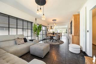 Op zoek naar een instapklare, energiezuinige woning met uitzonderlijk veel ruimte en tal van mogelijkheden? Deze luxueuze open bebouwing op een perceel van 741 m² combineert hedendaags wooncomfort met een rustige, groene ligging en een vlotte verbinding naar de E34. Dankzij de royale bewoonbare oppervlakte en de aparte woonunit biedt deze eigendom heel wat mogelijkheden, zoals een kangoeroewoning, praktijk aan huis, cohousing of een polyvalente ruimte.<br /><br />Indeling<br />Gelijkvloers<br />Bij het betreden van de woning komt de ruime inkomhal meteen uitnodigend over. De lichtrijke leefruimte sluit naadloos aan op de moderne open keuken, uitgerust met kwalitatieve toestellen zoals een stoomoven, oven, vaatwasser en koelkast. Dankzij de vele kastruimtes en het prachtige uitzicht op de tuin vormt deze ruimte het hart van de woning.<br /><br />Verder bevinden zich op het gelijkvloers:<br />- Praktische berging/wasplaats<br />- Gastentoilet<br />- Twee ruime slaapkamers van ca. 15 m² en 14 m²<br />- Recente, stijlvolle badkamer<br /><br />Aansluitend bevindt zich een afzonderlijke ruimte van ongeveer 40 m² die perfect dienst kan doen als woonunit, praktijkruimte, bureau of polyvalente ruimte. In deze ruimte is ook een gastentoilet aanwezig. Er is een rechtstreekse toegang tot de woning, maar ook een aparte ingang. <br /><br />De bovenverdieping beschikt over:<br />- Ruime slaapkamer van ca. 16 m²<br />- Ensuite badkamer<br /><br />De volledig omheinde en onderhoudsvriendelijke tuin vormt een heerlijke plek om in alle rust te genieten. Dankzij de twee terrassen is er op elk moment van de dag een aangename plek in de zon of schaduw. De ruime oprit biedt voldoende parkeergelegenheid en geeft toegang tot de garage van ca. 25 m².<br /><br />Extra troeven<br />- EPC-label B<br />- Zeer energiezuinige woning<br />- Elektrische rolluiken<br />- Nieuwe condensatieketel (2023)<br />- Zonnepanelen<br />- Conforme elektriciteitskeuring<br />- Vier airco's<br /><br />Een veelzijdige en perfect onderhouden woning waar ruimte, comfort en energiezuinigheid hand in hand gaan. Ideaal voor grote gezinnen of voor wie wonen en werken wil combineren op één locatie. Zeker een bezoek waard!
