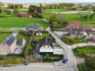 Het gelijkvloers omvat een inkomhal met gastentoilet, een zeer ruime en lichtrijke woonkamer met eetplaats en bureauruimte, volledig ingerichte...