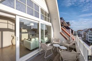 Zonnig en ruim duplex appartement met zuidgericht terras op wandelafstand van de winkels en het strand. Indeling: inkomhal met gastentoilet en vestiaire (met aansluiting voor combi wasmachine/droogkast). Technische ruimte/berging. Lichtrijke leefruimte met toegang tot het zonneterras. Volledig ingerichte keuken voorzien van alle apparatuur met eetplaats en toegang tot het terras achteraan. Berging. Op de verdieping: 1ste ruime slaapkamer met ingemaakte kasten en aansluitende badkamer (bad, lavabo en toilet). 2de slaapkamer met ingemaakte kasten. Douchekamer. Toilet op de nachthal. Privatieve kelder. Kleinschalige residentie met 1 appartement per verdiep vlakbij de zee. <br /><br />Contacteer ons om een bezoek in te plannen.