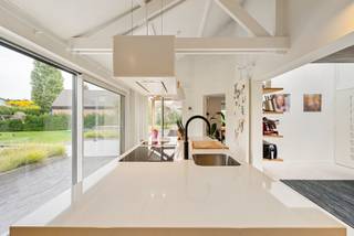 Op een bijzonder breed perceel van maar liefst 1.715 m² bevindt zich deze stijlvolle, hedendaagse woning van 322m²(bron EPC) waar architectuur, wooncomfort en buitenbeleving mooi samenvloeien. De ligging vormt daarbij een uitgesproken troef: de Kroonwinningstraat is een residentiële straat met een rechtstreekse aansluiting richting de Grote Ring, waardoor het centrum van Hasselt en de belangrijkste verbindingsassen vlot bereikbaar zijn.<br />De woning straalt een tijdloze, hedendaagse elegantie uit. Binnen zorgen royale raampartijen, open leefruimtes en de karaktervolle hoge plafonds met zichtbare dakstructuur voor een uitzonderlijk gevoel van ruimte en licht. Warme materialen, veel geïntegreerd maatwerk en een kwalitatief afwerkingsniveau geven het interieur een verfijnde maar tegelijk aangename en huiselijke uitstraling.<br />De leefruimtes staan sterk met elkaar in verbinding en kijken uit over de tuin. Wonen, tafelen en ontspannen vloeien natuurlijk in elkaar over, terwijl de openheid nergens ten koste gaat van gezelligheid. Het geheel werd duidelijk ontworpen met aandacht voor zichtlijnen, lichtinval en functionaliteit.<br />Met vier volwaardige slaapkamers en twee badkamers biedt de woning alle ruimte voor een gezin, zonder aan comfort of privacy in te boeten. Ook praktisch scoort het pand bijzonder sterk, onder meer dankzij de dubbele inpandige garage en de royale perceeloppervlakte.<br />Buiten wordt de architectuur doorgetrokken in een indrukwekkende, volledig aangelegde en inmiddels volwassen tuin. Strakke hagen, volwassen beplanting, ruime gazons en zorgvuldig gekozen terrassen creëren verschillende buitenkamers en zorgen tegelijk voor een bijzonder groen kader. Centraal in het tuinontwerp vormt de langgerekte zwemvijver een echte blikvanger. Het water, de beplanting en de open gazons versterken het gevoel van rust en ruimte dat op een perceel van deze omvang zo uitzonderlijk is nabij Hasselt.<br />Ook de omgeving draagt bij aan het bijzondere karakter van de locatie. In de Kroonwinningstraat bevindt zich het historische park De Kroonwinning, een landschappelijk park met grasveld, vijver en een waardevol bomenbestand. Inventaris Onroerend Erfgoed Tegelijkertijd blijft de stedelijke bereikbaarheid uitstekend: de straat sluit aan op de Gouverneur Roppesingel/Grote Ring en bevindt zich daarmee strategisch ten opzichte van Hasselt en de omliggende regio. Wegen en Verkeer<br />Kroonwinningstraat 72 is dan ook een woning voor wie niet wil kiezen tussen ruimte en bereikbaarheid, tussen architectuur en gezelligheid, of tussen stad en groen. Een uitzonderlijk breed perceel, een volwassen tuin met zwemvijver, vier slaapkamers, twee badkamers, een dubbele inpandige garage en een lichtrijk interieur met hoogwaardig maatwerk maken hiervan een bijzonder compleet woonverhaal op een gegeerde Hasseltse locatie.