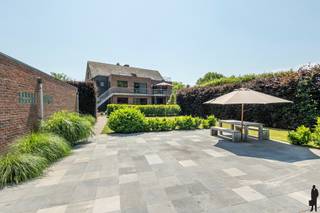 <div>
<p><strong>Ruime kangoeroewoning met twee volwaardige woonentiteiten op een perceel van ca. 3.116 m² in Beerse<br /><br /></strong>Op een rustige ligging, vlak bij het centrum van Beerse, bevindt zich deze uitzonderlijk <strong>ruime kangoeroewoning</strong> met twee volledig uitgeruste woonentiteiten. Dankzij de doordachte indeling biedt dit eigendom tal van mogelijkheden, zoals samenwonen met meerdere generaties, een combinatie van wonen en werken of een investering met dubbele bewoning.<br /><br />Beide wooneenheden beschikken over een <strong>eigen leefruimte</strong>, keuken, badkamer en slaapkamers, waardoor privacy en wooncomfort optimaal gegarandeerd zijn. Bovendien verbindt een <strong>personenlift</strong> alle verdiepingen, van de kelder tot de afgewerkte zolder, wat de woning bijzonder toegankelijk maakt.<br /><br /><strong>Gelijkvloerse woonentiteit<br /></strong>Via de inkomhal met gastentoilet betreedt u de eerste woonentiteit. De <strong>lichtrijke leefruimte</strong> biedt voldoende plaats voor een gezellige zithoek en eetkamer. Aansluitend bevindt zich de volledig <strong>ingerichte keuken</strong> met zicht op de tuin.<br /><br />Verder omvat deze verdieping <strong>drie volwaardige slaapkamers</strong>, een comfortabele badkamer met ligbad, douche en dubbele wastafel, evenals een bijzonder <strong>ruime wasplaats met maatwerkkasten</strong>.<br /><br /><strong>Woonentiteit op de eerste verdieping<br /></strong>De tweede woonentiteit beschikt eveneens over een <strong>ruime woonkamer</strong>, een volledig <strong>ingerichte leefkeuken</strong> en <strong>drie slaapkamers</strong>, waarvan één momenteel is ingericht als bureau. Ook hier is een<strong> ruime wasplaats</strong> voorzien. De badkamer is uitgerust met een douche, toilet en dubbele wastafel.<br /><br />Deze woonentiteit beschikt over <strong>twee terrassen</strong>, waarvan één met een trap naar de tuin.<br /><br /><strong>Extra ruimte en praktische voorzieningen<br /></strong>De<strong> afgewerkte zolderverdieping</strong> vormt een veelzijdige extra ruimte die perfect kan dienen als hobbykamer, speelruimte, bureau of extra berging.<br /><br />Daarnaast is de woning <strong>grotendeels onderkelderd</strong>, met verschillende praktische bergplaatsen en een aparte wijnkelder.<br /><br />Op het terrein bevinden zich <strong>twee ruime vrijstaande garages</strong> met automatische sectionaalpoorten. Eén garage beschikt over een extra bergruimte, terwijl de tweede is ingedeeld met een garage, berging, bureau, toilet én een eigen kelder. Bovendien is er nog een <strong>carport</strong> aanwezig en is er ruime parkeergelegenheid op eigen terrein.<br /><br />De volledig <strong>omheinde tuin</strong> biedt veel privacy en is bereikbaar via<strong> twee automatische toegangspoorten</strong>. De verschillende terrassen zorgen ervoor dat u op elk moment van de dag een aangename buitenplek vindt.<br /><br /><strong>Troeven</strong></p>
<ul>
<li>Kangoeroewoning met twee volledig uitgeruste woonentiteiten</li>
<li>EPC label B</li>
<li>Perceel van ca. 3.116 m²</li>
<li>Lift van kelder tot zolder</li>
<li>In totaal 6 slaapkamers</li>
<li>Twee ingerichte keukens en twee badkamers</li>
<li>Afgewerkte zolder met diverse gebruiksmogelijkheden</li>
<li>Grotendeels onderkelderd</li>
<li>Twee vrijstaande garages, carport en ruime parkeermogelijkheden</li>
<li>Volledig omheinde tuin met twee automatische toegangspoorten</li>
<li>Vloerverwarming (uitgezonderd zolder)</li>
<li>Elektrische rolluiken</li>
<li>Regenwaterrecuperatie via meerdere regenwaterputten (in totaal 27.500 liter)</li>
</ul>
</div>