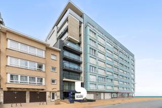 Op amper 30 meter van de zeedijk bevindt zich dit moderne en lichtrijke gelijkvloerse appartement met zijdelings zeezicht, twee slaapkamers en een exclusief zonneterras van maar liefst 28 m². De recente residentie onderscheidt zich door haar eigentijdse architectuur en biedt dankzij slechts één appartement per verdieping een extra gevoel van rust en privacy.<br /><br />Het appartement is stijlvol en luxueus ingericht, met bijzondere aandacht voor een optimaal ruimtegebruik. De praktische inbouwkasten, waaronder een opklapbaar bed, zorgen voor extra comfort en opbergruimte. Met twee slaapkamers biedt het appartement plaats aan vier personen, waardoor het ideaal is als tweede verblijf aan zee of als comfortabele eigen woonst.<br /><br />Een absolute troef is het ruime, volledig afgesloten zonneterras van 28 m², rechtstreeks toegankelijk vanuit het appartement en ideaal om in alle privacy van de zon te genieten. Dankzij de ligging op het gelijkvloers is het appartement bovendien bijzonder vlot toegankelijk.<br /><br />De residentie beschikt over een ruime lift die conform is aan de geldende normen. Daarnaast zijn er een gemeenschappelijke fietsenberging en extra bergruimte, zowel in het appartement zelf als in de kelder.<br /><br />De ligging is bijzonder gunstig: op wandelafstand vind je het openbaar vervoer, restaurants, winkels, het warenhuis, het nieuwe stedelijke zwembad en diverse sportfaciliteiten, waaronder golf, voetbal en basketbal.<br /><br />Tot slot beschikt het appartement over een blanco elektrische keuring.