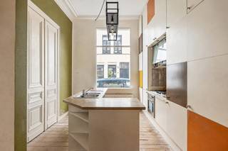 Wonen op één van de meest gegeerde locaties van Antwerpen? Dit charmante, compacte herenhuis bevindt zich in het geliefde Zurenborg, een buurt die bekendstaat om haar prachtige architectuur, gezellige straten en bruisende sfeer.
Op wandelafstand vind je tal van populaire koffiebars, restaurants en gezellige horecazaken, terwijl ook het stadscentrum en belangrijke invalswegen vlot bereikbaar zijn. Een ideale uitvalsbasis voor wie houdt van het stadsleven, maar tegelijk wil thuiskomen in een karaktervolle en aangename woonbuurt.
De woning zelf combineert authentieke elementen met een verrassend open vloerplan. De huidige indeling biedt een fijne ruimtelijkheid, maar laat tegelijk verschillende mogelijkheden toe om de woning volledig naar eigen smaak en woonbehoeften in te richten.
Bij het binnenkomen verwelkomt de inkomhal je meteen met authentieke vloertegels die de sfeer van het huis perfect neerzetten. Van hieruit wandel je door naar de eetkamer, met vooraan de keuken. Achteraan bevindt zich de eerste badkamer, ingericht met een douche, toilet en aansluitend een praktische inloopdressing.
De karaktervolle, gezandstraalde trap leidt naar de eerste verdieping. Deze werd momenteel volledig opengewerkt en combineert een eerste slaapkamer met de leefruimte. Wie liever afzonderlijke kamers creëert, kan deze verdieping eenvoudig opnieuw opdelen. Authentieke details en een prachtige ingebouwde boekenkast zorgen hier voor extra cachet.
Op de tweede verdieping bevindt zich de tweede slaapkamer, voorzien van ingemaakte kasten. De open badkamer geeft deze verdieping een bijzonder loftgevoel en is uitgerust met zowel een ligbad als een douche.
Een woning voor liefhebbers van karakter, open ruimtes en authentieke details, op een locatie die moeilijk te evenaren is. Compact in oppervlakte, maar bijzonder in uitstraling én mogelijkheden.
Een charmante stadswoning met een eigenzinnig karakter, midden in het geliefde Zurenborg.