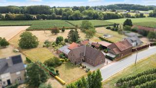 TIELT-WINGE- Ruime woning met bijgebouwen en binnenkoer op 96a<br /><br />Gelegen in het landelijke Sint-Joris-Winge vinden we deze ruime woning met bijgebouwen en een schuur. Een eigendom met een stevige basis en tal van mogelijkheden voor wie op zoek is naar ruimte, rust en een landelijke omgeving.<br /><br />De woning is te renoveren, maar beschikt over een degelijke constructie en biedt dankzij de ruime plaatsen heel wat potentieel. Op het gelijkvloers komen we binnen in een ruime inkomhal met apart toilet, een bureel of slaapkamer en een badkamer. Verder vinden we een ruime leefruimte met eetplaats, aansluitend een grote keuken. Achter de keuken bevindt zich een zij-ingang met aansluitend een was- en bergruimte.<br /><br />De verdieping biedt maar liefst vier zeer ruime slaapkamers, aangevuld met verschillende bergplaatsen, een badkamer en een apart toilet.<br /><br />Aansluitend aan de woning bevindt zich een grote schuur die mits renovatie kan worden ingericht als polyvalente ruimte, bureel, hobbyruimte of stalling. Rond de binnenkoer bevinden zich daarnaast verschillende stalgebouwen en een ruime schuur. Hoewel ook deze gebouwen renovatie vragen, bieden ze bijzonder veel mogelijkheden voor opslag, het houden van dieren of andere doeleinden.<br /><br />Achter de gebouwen strekt het weiland zich volledig open uit. Mits het verwijderen van enkele bijgebouwen kan bovendien een prachtig open zicht vanaf de binnenkoer en eventueel woning worden gecreëerd, wat de landelijke sfeer van het geheel nog verder versterkt.<br /><br />Deze eigendom is dan ook bijzonder geschikt voor wie op zoek is naar een ruime woning met veel bijgebouwen, opslag en grond, en dit in een rustige, landelijke omgeving.<br /><br />Bent u op zoek naar een ruime landelijke woning met karakter en tal van mogelijkheden? Dan is deze eigendom zeker een bezoek waard. Aarzel niet om ons te contacteren: 053/60.65.66.