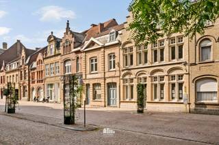 Op een toplocatie in de Rijselstraat bevindt zich deze charmante herenwoning boordevol karakter. Vanuit de woning geniet u van een prachtig zicht op de indrukwekkende Sint-Pieterskerk, terwijl u zich op wandelafstand bevindt van alle voorzieningen die het stadscentrum te bieden heeft.<br /><br />Bij het betreden van de woning komt u in de gezellige leefruimte, gevolgd door een aparte eetplaats en een volledig ingerichte keuken. De badkamer is uitgerust met een dubbel lavabomeubel en een ruime inloopdouche. Daarnaast beschikt de woning over een praktische kelder.<br /><br />Een absolute meerwaarde is de smalle, inpandige garage die doorloopt tot een ruime berging en rechtstreeks toegang biedt tot de tuin. Ideaal voor het stallen van fietsen, het plaatsen van vuilnisbakken of het opbergen van tuinmateriaal.<br /><br />Via de authentieke trappenhal bereikt u de eerste verdieping, waar zich twee bijzonder ruime slaapkamers bevinden. Op de tweede verdieping is momenteel een derde slaapkamer ingericht, met de mogelijkheid om eenvoudig een vierde slaapkamer te creëren.<br /><br />Buiten geniet u van een volledig afgesloten, zonnige stadstuin met een handige buitenberging – een heerlijke plek om in alle rust te ontspannen.<br /><br />Bent u op zoek naar een karaktervolle herenwoning met veel ruimte, authentieke elementen, een zonnige tuin en een unieke ligging met prachtig zicht op de Sint-Pieterskerk? Dan is deze woning beslist een bezoek waard!