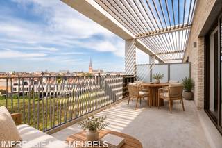 <p><strong>Residentie Tamboer – uw eigen ritme, midden in Turnhout</strong></p>
<p>De ochtend beginnen met een koffie op uw terras, terwijl de stad langzaam ontwaakt. Thuiskomen in een licht appartement, waar alles klaarstaat voor uw volgende hoofdstuk. In Residentie Tamboer hoeft u dat niet bij plannen te laten: dit appartement is volledig afgewerkt en klaar voor bewoning. U kunt meteen verhuizen.</p>
<p>Met 92 m² bewoonbare oppervlakte en een terras van 20 m² vindt u hier een aangename balans tussen ruimte, comfort en buitenleven. Het weidse zicht over de omgeving geeft uw dagelijkse koffiemoment nét dat beetje extra.</p>
<p>In de inkomhal is plaats voor een vestiaire. Via een glazen deur komt u in de open leefruimte, waar de zithoek, eetruimte en volledig uitgeruste keuken samen het hart van uw woning vormen. Hier kookt u terwijl uw gasten nog aan tafel zitten, of geniet u van een rustige avond in de zetel. Ook voor een aangename bureauhoek is ruimte voorzien. Het grote schuifraam verbindt de leefruimte met het terras en laat het daglicht royaal binnen.</p>
<p>De twee slaapkamers liggen aan de achterzijde en kijken uit over de binnentuin. De badkamer biedt een ruime inloopdouche en dubbele wastafel. Het aparte toilet bevindt zich op de nachthal.</p>
<p><strong>Comfortabel wonen, zuinig leven</strong></p>
<p>De appartementen in Residentie Tamboer zijn BEN: bijna-energieneutraal, met een E-peil van maximaal E30. Een eigen warmtepomp en vloerverwarming zorgen voor aangenaam wooncomfort en een zeer energiezuinige woning. Zo kiest u voor comfort vandaag én een beperkt energieverbruik op lange termijn.</p>
<p><strong>Groot in mogelijkheden, aangenaam in schaal</strong></p>
<p>Eigentijdse architectuur, warme materialen en groene gevels geven Residentie Tamboer een herkenbaar karakter. Het project is opgedeeld in compartimenten, elk met een eigen trap en lift. Zo geniet u van de mogelijkheden van een grotere residentie, terwijl u de gemeenschappelijke delen met slechts een beperkt aantal andere appartementen deelt.</p>
<p>Uw fiets vindt een plaats in de ruime fietsenstalling op het gelijkvloers. Uw wagen parkeert u in de afgesloten parkeerkelder.</p>
<p>De vraagprijs van dit appartement bedraagt € 315.400 exclusief kosten. Parkeerplaatsen zijn verkrijgbaar vanaf € 20.900 en bergingen vanaf € 4.500. Inclusief btw, registratierechten, notariskosten, aansluitingskosten nutsvoorzieningen, één parkeerplaats en één berging bedraagt de totale aankoopprijs circa € 417.000.</p>
<p>Achter Residentie Tamboer staat DC Belgium, een ervaren Belgische projectontwikkelaar met aandacht voor woonkwaliteit en groen.</p>
<p><strong>Kom kijken, voel de ruimte en ontdek hoe snel dit uw nieuwe thuis kan zijn.</strong></p>