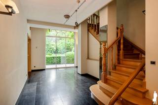 <p>Op een <strong>absolute toplocatie in het prestigieuze Kapellenbos</strong>, aan de Franselei 55, bevindt zich deze <strong>uitzonderlijke villa in kasteelhoevestijl</strong> op een <strong>residentieel perceel van ca. 5.700 m²</strong>. De ligging combineert <strong>uitstekende bereikbaarheid</strong> met <strong>volledige rust, privacy en groenbeleving</strong><span>.<br /><br /></span><strong>Indeling gelijkvloers</strong><br />De villa wordt bereikt via een <strong>monumentale kassei-oprijlaan</strong> en verwelkomt u in een <strong>ruime inkomhal</strong> met vestiaire en gastentoilet. Rechts bevinden zich twee <strong>stijlvolle leefruimtes met open haard</strong> (ca. <strong>55 m²</strong>) en zicht op de tuin. Links situeren zich de <strong>eetkamer</strong> (ca. <strong>20 m²</strong>) en de <strong>ruime eet-leefkeuken</strong> (ca. <strong>25 m²</strong>) met <strong>natuurstenen werkbladen, kookeiland en kwalitatieve toestellen</strong>, en met <strong>directe connectie naar terrassen en tuin</strong>. Aansluitend is er een <strong>volwaardige bijkeuken/wasplaats met douche</strong>.</p>
<p><strong>Indeling eerste verdieping</strong><br />De nachthal met vide geeft toegang tot <strong>vier slaapkamers en drie badkamers</strong>. De <strong>master bedroom</strong> (ca. <strong>25 m²</strong>) beschikt over een <strong>dressing en badkamer ensuite</strong>. De overige slaapkamers meten ca. <strong>18 m²</strong>, <strong>16 m²</strong> en <strong>14 m²</strong>. Eén van de badkamers is uitgerust met een <strong>sauna</strong>.</p>
<p><strong>Indeling tweede verdieping</strong><br />De tweede verdieping omvat een <strong>vijfde slaapkamer</strong> (ca. <strong>20 m²</strong>) met <strong>badkamer ensuite</strong>, ideaal als <strong>gastensuite of tienerkamer</strong>.</p>
<p><strong>Bijkomende ruimtes</strong><br />Een aparte zij-ingang geeft toegang tot een <strong>bureelruimte</strong> (ca. <strong>22 m²</strong>), een <strong>sportkamer</strong>, een <strong>logeerkamer/conciergerieruimte met badkamer</strong> en een <strong>dubbele inpandige garage</strong>, wat dit eigendom ook geschikt maakt voor <strong>praktijk of kantoor aan huis</strong>.</p>
<p><strong>Tuin</strong><br />De <strong>fraai aangelegde parktuin</strong> biedt <strong>volledige rust en privacy</strong> en is ingericht met <strong>strakke haagstructuren, volwassen bomen, een grote vijver, meerdere zonneterrassen</strong> en een <strong>eikenhouten bijgebouw</strong>. Een <strong>poort naar de achtergelegen dreef</strong> versterkt het exclusieve domeinkarakter.</p>
<p><strong>Bijzonderheden</strong><br /><strong>Absolute topligging in Kapellenbos</strong>, <strong>perceel ca. 5.700 m²</strong>, <strong>kasteelhoevestijl</strong>, <strong>monumentale oprijlaan</strong>, <strong>open haard</strong>, <strong>kwalitatieve leefkeuken</strong>, <strong>5 slaapkamers en 4 badkamers</strong>, <strong>sauna</strong>, <strong>bureau- en praktijkmogelijkheden</strong>, <strong>dubbele inpandige garage</strong>, <strong>bijgebouw</strong>, <strong>parktuin met vijver</strong>, <strong>uitstekende privacy</strong>.</p>
