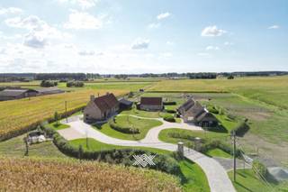 Deze vrijstaande villa onderscheidt zich op meerdere vlakken, met als eerste grote troef haar bijzonder rustige ligging te midden van het groen. Dankzij de open omgeving geniet men hier van een weids en rustgevend uitzicht, wat het gevoel van ruimte en privacy alleen maar versterkt. De aanwezigheid van talloze fiets- en wandelroutes in de directe omgeving maakt deze locatie uitermate geschikt voor wie graag in alle rust van de natuur wil genieten. Tegelijkertijd is er een vlotte aansluiting met de voornaamste invalswegen, wat zorgt voor een comfortabele bereikbaarheid richting omliggende gemeenten en steden.<br /><br />De woning heeft een bewoonbare oppervlakte van ongeveer 235 m² en staat op een ruim perceel van 11.431 m². Bij de bouw werd duidelijk gekozen voor duurzame en kwalitatieve materialen, met een zorgvuldige afstemming tussen de verschillende elementen. Dit komt onder meer tot uiting in de keuze van de vloerbekleding, het maatwerk in het schrijnwerk en de volledig uitgeruste keuken, die voorzien is van diverse inbouwtoestellen.<br /><br />De woning wordt gekenmerkt door een overvloed aan natuurlijk licht, te danken aan de vele raampartijen die in combinatie met de verhoogde plafondhoogtes zorgen voor een bijzonder ruimtelijk en open gevoel. Vanuit vrijwel elke ruimte is er zicht op het omliggende landschap, wat bijdraagt aan een aangename en harmonieuze leefomgeving.<br /><br />De villa beschikt over vijf volwaardige slaapkamers en twee badkamers, verdeeld over zowel het gelijkvloers als de verdieping. Deze indeling biedt ruime mogelijkheden qua gebruik en inrichting.<br /><br />Buiten vervolledigen meerdere extra’s het geheel, waaronder een ruime carport, een gunstige zuidwestelijke oriëntatie van het perceel, een fraai aangelegde tuin, een zwembad, en de aanwezigheid van zonnepanelen.<br /><br />Op het perceel bevinden zich daarnaast twee afzonderlijke bijgebouwen. Het eerste gebouw is volledig uitgerust met voorzieningen zoals verwarming, keukeninstallatie en sanitair, wat de ruimte flexibel inzetbaar maakt. Het tweede bijgebouw heeft een oppervlakte van circa 345 m² en wordt momenteel deels gebruikt als opbergruimte en deels als stalruimte.<br /><br />Centrale verwarming op aardgas (vloerverwarming + gashaard) / bijgebouw verwarmd door middel van een warmtepomp (lucht-lucht) / Epeil: E34 / EK conform / 30 zonnepanelen / asbestveilig / mogelijkheid tot huren aangrenzende weiden<br /><br />Benieuwd naar deze eigendom? Maak dan vrijblijvend uw afspraak via guillian@landbergh.be of 09 278 78 79.