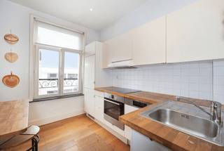 Entre l’énergie du piétonnier de la Chaussée d’Ixelles et l’ambiance ultra recherchée de la Place Saint-Boniface, découvrez un appartement qui a tout compris à l’art de vivre ixellois.<br /><br />Installé au 4ᵉ étage d’un élégant immeuble de style éclectique, ce bel appartement lumineux de ±81 m² combine charme de l’ancien et confort actuel. Dès l’entrée, l’atmosphère chaleureuse opère : séjour agréable sur plancher, baigné de lumière, ouvert sur une cuisine super équipée pensée pour le quotidien comme pour recevoir.<br /><br />Côté nuit, une grande chambre à l’arrière garantit calme et intimité, loin de l’animation du quartier. La salle de bains, confortable et fonctionnelle, complète harmonieusement l’ensemble.<br /><br />Atouts supplémentaires : grande cave, électricité conforme, chaudière individuelle au gaz — un bien sans mauvaises surprises.<br /><br />Actuellement loué 900 €/mois (bail 9 ans en cours depuis avril 2021), il représente aussi une opportunité d’investissement solide dans l’un des quartiers les plus vivants et prisés de Bruxelles - Possibilité occup. personnelle moyennant renon 6 mois à donner au locataire à l'acte. Charges : ± 30€/mois. PEB G.<br /><br />Un appartement de caractère, une localisation exceptionnelle, un vrai coup de cœur ! Cachet bruxellois &amp; adresse coup de cœur ! <br />
<p><u>4<sup>e</sup> étage</u> : Appt "A4" (Quotités : 136/100èmes)</p>
<ul>
<li>Hall d’entrée avec vestiaire</li>
<li>Toilettes</li>
<li>Living de ±20m² sur plancher</li>
<li>Cuisine super équipée de ±8m²</li>
<li>Chambre arrière de ±20m²</li>
<li>Salle de bains (baignoire, 2 lavabos, coin lave-linge et chaufferie)</li>
</ul>
<p><u>Sous-sol</u> : Cave C4</p>