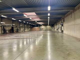 Samengesteld uit twee productiehallen van 933 m² en 1.000 m², met een vrije hoogte onder dak van ca. 5,50 m.
Vlotte toegang via twee sectionale poorten, waarvan één met inpandige laad- en loskade. De achterste hal is uitgerust met 6 airconditionings.
Een administratieve zone omvat:
een inkomhal,
twee kantoren,
een bergruimte,
sanitaire voorzieningen en kleedkamers H/D,
evenals een refter met kitchenette.
Het gebouw is opgetrokken in een betonnen structuur met gladde industriële betonvloer, betonnen gevels en een vlakke metalen dakconstructie. Verwarming via twee mazoutketels (kantoren en hallen).
Technische installaties aanwezig (elektriciteit, sanitair, alarm, hydranten).
Buiten: geasfalteerde parkeer- en toegangswegen, oprijlaan naar de laad- en loskade, groenzone.
👉 Functioneel bedrijfsgebouw met ruime volumes en groot potentieel voor industriële of logistieke activiteiten.