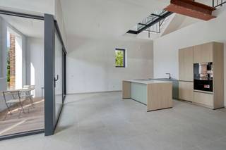 This unique loft apartment is located in the rural and peaceful town of Sint-Pieters-Kapelle, housed in a fully renovated former school building. Here, authentic charm and contemporary living comfort go hand in hand. Through the light-filled entry hall, you enter the spacious living area, which flows seamlessly into the open kitchen, where large windows provide an abundance of natural light and a beautiful view of the patio and garden.

On the first floor, there are two spacious bedrooms and a stylish bathroom featuring both a bathtub and a walk-in shower. The attic floor offers two additional bedrooms and provides access to a second terrace.

The home is exceptionally energy-efficient thanks to underfloor heating and solar panels, resulting in a favorable EPC rating and a pleasant living environment. In addition, you’ll enjoy an exemption from cadastral income tax for the first five years. The home also features a private garden, private parking spaces, and a shared bicycle storage area.

**Highlights:**

* Unique loft apartment in a renovated school building
* Quiet, green location
* 4 full-sized bedrooms
* Underfloor heating and solar panels
* Exemption from cadastral income tax for the first 5 years
* Option to purchase at registration tax rates
* Private garden, parking spaces, and bicycle storage

A unique opportunity for those seeking character, space, and sustainable living comfort.