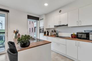 U betreedt het appartement via de inkomhal met vestiaire en gastentoilet.De lichtrijke leefruimte met open keuken geeft uit op het terras en de fraai...