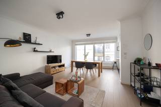 In a central and sought after location, you will find this move in ready apartment (85 m²) with two spacious bedrooms and a south facing terrace. Thanks to the high quality finish and well thought out layout, you will enjoy stylish living within walking distance of shops, restaurants, and public transport.

You enter the apartment through the entrance hall with cloakroom space and a separate guest toilet with hand basin. The bright living area spans the full width of the façade and offers a pleasant view thanks to the large windows. On the street side, there is a fully equipped, modern open corner kitchen.

A continuous parquet floor runs throughout the apartment and pairs perfectly with the clean architectural style. The bathroom is finished tastefully with a vanity unit, illuminated mirror, walk in shower, towel radiator, and connections for a washing machine and dryer.

Both bedrooms are located at the quiet rear of the apartment and provide direct access to the sunny terrace, where you can fully enjoy the south facing orientation.

Key features
• Central location with excellent accessibility
• Two spacious bedrooms
• Sunny south facing terrace
• Private cellar storage

Technical details: PVC double glazing, individual meters.
Common charges: 80 euros per month.
Urban planning information requested.