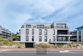 Appartement penthouse récent et luxueusement fini de 180 m², situé dans un emplacement de choix absolu avec des vues panoramiques sur les dunes protégées de Houtsaeger. Cette propriété exceptionnelle combine un agencement réfléchi avec des matériaux durables de haute qualité et une orientation écologique rare. Doté de trois chambres spacieuses et de deux salles de bains, l'appartement offre une expérience de vie unique grâce à ses grandes terrasses orientées vers le soleil, où vous pourrez profiter du calme et de la nature tout au long de la journée.<br />L'espace de vie lumineux avec cuisine ouverte s'intègre parfaitement à la terrasse et constitue le cœur battant de cette propriété. Grâce au chauffage par le sol et aux brise-soleil à commande électrique, le climat intérieur est toujours agréable. L'appartement est équipé d'une pompe à chaleur, d'un système de ventilation de type D et de pas moins de 24 panneaux solaires privés, ce qui contribue à sa neutralité énergétique. La récupération d'eau de pluie de 8000 litres avec un système d'arrosage automatique pour les jardinières intégrées souligne le caractère écologique de cette propriété unique.<br />La chambre principale dispose d'une salle de bains attenante avec baignoire, douche à l'italienne et double lavabo. Il y a également une deuxième salle de bains avec douche à l'italienne et des toilettes supplémentaires, ainsi qu'un local technique pratique avec une buanderie. Des détecteurs de mouvement assurent l'éclairage automatique des toilettes, du hall de nuit, du local technique, du sous-sol et du garage, entre autres. Grâce à son agencement intelligent et à son double espace de vie, ce penthouse offre également des possibilités en tant que maison kangourou ou pour les professionnels à la recherche d'une combinaison confortable de vie et de travail. Un grand garage souterrain avec station de recharge électrique peut être acheté en option. L'emplacement est idéal : à proximité du célèbre club de sports nautiques KYC et à quelques pas des hauts lieux culinaires et des boutiques de Sint-Idesbald. Une opportunité exceptionnelle pour ceux qui recherchent l'espace, le confort, la nature et la durabilité dans un emplacement de choix au bord de la mer. EPC : -4 kWh/m². Prix demandé : 1135000€.