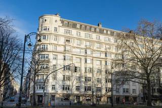 In het hart van een van de meest iconische adressen van Brussel bevindt zich dit prestigieuze appartement, gelegen in een prachtig art-decogebouw uit de jaren 30. Achter de elegante en tijdloze gevel onthult het gebouw gemeenschappelijke delen met een uitzonderlijk karakter, verfraaid met edele materialen, sierlijk smeedwerk en zorgvuldig bewaarde architecturale details. Een zeldzame woonomgeving die verfijning, authenticiteit en Brusselse charme perfect samenbrengt.<br /><br />Gelegen op de 3de verdieping biedt dit appartement een privatieve oppervlakte van ca. 237 m², aangevuld met twee terrassen van samen ca. 13 m². Meteen bij het binnenkomen vallen de royale volumes op, die het volledige karakter van de burgerlijke architectuur uit die periode weerspiegelen.<br /><br />De leefruimtes baden in het licht en bestaan uit prachtige salons in enfilade met mooie doorkijken, aangevuld met een elegante eetkamer. Het geheel charmeert door zijn verfijnde sfeer, harmonieuze verhoudingen en authentieke uitstraling.<br /><br />Het nachtgedeelte omvat drie mooie slaapkamers, waaronder een comfortabele master bedroom, evenals twee badkamers. De indeling is bijzonder vlot en zorgt voor een natuurlijke scheiding tussen de leefruimtes en de meer private vertrekken.<br /><br />Als extra beschikt het appartement over twee dienstkamers en een ruime kelder, een zeldzaam voordeel voor dit type eigendom. EPC: E+<br /><br />Een uitzonderlijk pand voor liefhebbers van architectuur, royale volumes en prestigieuze adressen.<br />
<p><span>3de verdieping links:</span></p>
<ul>
<li>Inkomhal van ± 20 m²</li>
<li>3 ontvangstruimtes van in totaal ± 85 m² - </li>
<li>Wasruimte</li>
<li>3 toiletten</li>
<li>2 badkamers</li>
<li>Keuken van ± 20 m²</li>
<li>Gesloten terras van ± 12 m²</li>
<li>Slaapkamer 1 van ± 17 m²</li>
<li>Slaapkamer 2 van ± 20 m²</li>
<li>Slaapkamer 3 van ± 17 m²</li>
</ul>
<br />Kelder nr. 10<br />Dienstkamers nr. 9 &amp; 33