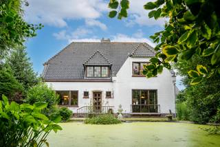 Verscholen achter een statige haag en een toegangspoort langs de Pittemstraat bevindt zich deze karaktervolle jaren '50-villa, een eigendom die de degelijkheid, charme en royale ruimtes van weleer perfect combineert met een uitzonderlijke ligging. Via de private oprijlaan bereikt u de woning, waar ruime parkeermogelijkheden op eigen terrein voor extra comfort zorgen.<br /><br />Bij het binnenkomen wordt u verwelkomd in een royale inkomhal met afzonderlijke vestiaire en gastentoilet. De authentieke dubbele deur leidt naar de bijzonder ruime leefruimte, die naadloos overgaat in de geïntegreerde orangerie. Hier geniet u in alle rust van een prachtig zicht op de fraai aangelegde, volledig private tuin en het zonneterras.<br /><br />Daarnaast beschikt de woning over een ruime, afzonderlijke keuken met aansluitend een tweede leefvleugel die ingericht is als gezellige eet- en zitruimte. Verder vindt u op het gelijkvloers een praktische was- en berging, evenals een ruime kelder.<br /><br />De eerste verdieping omvat een royale nachthal, vier volwaardige en bijzonder ruime slaapkamers en een grote badkamer. Via een vaste trap bereikt u de tweede verdieping, momenteel opgedeeld in twee zolderruimtes, die zich uitstekend lenen voor de inrichting van extra slaapkamers, een hobbyruimte, bureau of polyvalente ruimte.<br /><br />Een absolute meerwaarde vormen de drie afzonderlijke loodsen naast de villa. Deze bieden tal van mogelijkheden voor opslag, een zelfstandige activiteit, een atelier of een combinatie van wonen en werken.<br /><br />Bent u op zoek naar een karaktervolle woning met uitzonderlijk veel ruimte, privacy en potentieel, waar u wonen en professioneel gebruik moeiteloos kunt combineren op een strategische locatie? Dan is deze unieke eigendom zonder twijfel een bezoek waard.<br /><br />Schrijf u vandaag nog in voor het exclusieve lanceermoment op woensdag 29 juli. U ontvangt een persoonlijk bezoekmoment, het volledige verkoopdossier en de mogelijkheid om nadien een bod uit te brengen.<br /><br />(De vermelde prijs betreft een richtprijs).