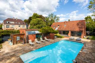 Moderne villa gelegen op 100m van het centrum van Bilzen, Wijsstraat 1.<br /><br />Unieke locatie op een boogscheut van het marktplein van het bruisende Bilzen, shoppingstad gekend om haar gezellige terrasjes.<br />De villa is gelegen in een mooie groene omgeving vlakbij het stadspark en het natuurdomein De Katteberg. Ook sport- en cultuurfaciliteiten bevinden zich vlakbij met cultureel centrum De Kimpel, het stedelijk zwembad en een befaamde tennis- en padelclub.<br />Alle belangrijke invalswegen zijn vlot bereikbaar op korte afstand, de autosnelweg bevindt zich op 1,5km.<br /><br />Kortom, alle faciliteiten binnen handbereik, in het centrum van Bilzen en dit in een groene en rustige omgeving!<br /><br />Deze riante villa met praktijkruimte is gelegen op een omheind perceel van 17A65CA en biedt een bewoonbare oppervlakte van 440m².<br /><br /><br />Deze villa met een doordachte architectuur diverse invulmogelijkheden voor vrij beroep, kantoor, duowoonst,...<br />De woning telt 5 slaapkamers en is volledig onderkelderd. In de zuidgeoriënteerde tuin is er een ruim openluchtzwembad.<br /><br />De aangename lichtinvallen, de verbondenheid tussen alle vertrekken via open toegang en de ruimtelijkheid zorgen voor een uiterst aangename woonbeleving.<br /><br />De woning (340m²) is op het gelijkvloers ingedeeld met een centrale inkomhal met open toegang tot alle leefvertrekken. Hier tref je een luxueus afgewerkt gastentoilet. Via de leefruimte en de keuken is er rechtstreeks toegang tot de binnentuin met zwembad. De leefruimte omvat een harmonieus geheel van zitruimte, TV-ruimte met ingebouwde haard, bureelhoek en eetkamer. Aansluitend is er een hedendaagse ingerichte keuken met keukeneiland afgewerkt in Corian.<br />Verder vind je op deze verdieping een praktische wasruimte, 2 bergruimten en een inpandige garage voor 2 wagens.<br /> <br />Op de verdieping zorgen diverse overdekte patio's voor een zeer lichtrijke nachthal. Hier zijn er 5 slaapkamers, 2 ingerichte trendy badkamers en een linnenkamer.<br /><br />Een lange hal voorzien van aangebouwde kastenwand verbindt de woning met de praktijkruimte (100m²). Deze is ingedeeld met een aparte inkomhal, een gastentoilet, een leefruimte, een volledig ingerichte moderne keuken en een berging.<br /><br />De woning is volledig onderkelderd met een CV-ruimte, diverse bergruimten en kruipkelders.<br /><br />Het zwembad van maar liefst 14m x 6m is voorzien van 2 inspuitfonteinen en werd rondom afgewerkt stijlvolle natuursteen.<br /><br />Het perceel is volledig omheind en omhaagd en biedt de bewoners maximale privacy. Veiligheid wordt gegarandeerd door de 6 buitencamera's en een alarmsysteem. Aan de voor- en achterzijde is er een automatische toegangspoort.<br /><br />Enkele van de voornaamste troeven van deze unieke woning zijn:<br /><br />- Zeldzame locatie nabij het centrum van Bilzen, vlakbij voornaamste invalsweg, cultureel centrum De Kimpel en het sportcentrum. En dat alles in een groene omgeving vlakbij natuurdomein De Katteberg.<br />- Ruim perceel van 17A65CA, zuid georiënteerd.<br />- Hedendaagse exclusieve villa met 5 slaapkamers.<br />- Prakrijkruimte biedt invulmogelijkheid voor vrij beroep, kantoor, duowoonst,.. Aparte toegang, voldoende parkeermogelijkheid zowel op het perceel als op de naastgelegen publieke parking.<br />- Woning is deels gerenoveerd aan de binnenzijde: reeds nieuwe keuken/sanitair/verwarming/parketvloer aanwezig. Alle binnendeuren worden vervangen door plafondhoge deuren. <br />- Met ruim openluchtzwembad, .<br /><br />Voor meer info of een bezoek ter plaatse, contacteer ons op 0473 79 29 30 of mail naar luc@vestio.com<br /><br /><br /><br /><br /><br /><br /><br /><br /><br /><br /><br /><br /><br /><br />