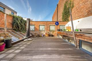 <p><span>Wonen in een van de meest gegeerde buurten van 2018 Antwerpen? In de rustige Sanderusstraat, vlakbij het Oud Justitiepaleis en de Leien, ontdek je deze uitzonderlijk ruime woning met maar liefst ca. 427 m² bewoonbare oppervlakte. Met een inpandige garage, groot atelier, tweede ingang voor commerciële activiteit, zonnepanelen met batterijen én een zalig westgericht dakterras is dit een pand met eindeloos veel mogelijkheden</span></p><p><span> </span></p><p><span>Wonen en werken in stijl</span></p><p><span>Je komt binnen via de inkomhal met stalen deur en bovenlicht. Van hieruit heb je toegang tot het atelier, de polyvalente ruimte en de trap naar boven. De polyvalente ruimte op het gelijkvloers (ca. 55 m²) is vandaag ingericht met keuken en leefgedeelte en baadt in het licht dankzij de vele oostgerichte ramen. De warme parketvloer en de connectie met het koertje maken dit een bijzonder aangename plek. Ideaal als praktijkruimte, studio, kangoeroewoning of aparte werkplek. Aansluitend vind je een eerste badkamer met lavabomeubel, toilet, handdoekradiator en douchecabine.</span></p><p><span>De inpandige garage heeft een indrukwekkende poorthoogte van 3,3 meter en een breedte van 3 meter — perfect voor wagen én fietsen. Via de garage bereik je de ruime, droge kelder én het achterliggende atelier.</span></p><p><span>Het atelier (ca.65 m²) met een plafondhoogte van 3,5 meter en dakramen is een droom voor doe-het-zelvers, zelfstandigen of hobbyisten. Momenteel ingericht als schrijnwerkerij, maar perfect inzetbaar als werkplaats, studio of opslagruimte. Extra troef: atelier is eveneens onderkelderd.  </span></p><p><span> </span></p><p><span>Leven op niveau</span></p><p><span>Op de eerste verdieping ontvouwt zich het hart van de woning: een open keuken met leefruimte van maar liefst ca.59 m². De keuken is hoogwaardig afgewerkt met een massief stenen werkblad, inductievuur, oven, microgolf, vaatwasser, glazen spatwand en overvloedige kastruimte. Alles sluit naadloos aan bij het maatwerk en de warme houtaccenten die doorheen de woning zijn doorgetrokken (renovatie van deze verdieping in 2021).  Aansluitend bevindt zich de zitruimte met kachel — open verbonden, maar toch gezellig afgescheiden. </span></p><p><span>Vanuit deze ruimte, alsook vanuit de berging met ingemaakte kasten heb je toegang tot het indrukwekkende westgerichte dakterras van 70 m². Hier geniet je van middag- en avondzon met zicht op de karaktervolle houten gevelafwerking achteraan. Een unieke buitenruimte in de stad.</span></p><p><span>Op de tussenverdieping bevindt zich nog een wasruimte met ingemaakte kasten en praktische wasinstallatie.</span></p><p><span> </span></p><p><span>Ruimte voor het hele gezin</span></p><p><span>De tweede verdieping telt een gigantische slaapkamer van ca. 38,5 m² (momenteel met kastenwand), perfect als master of opdeelbaar naar wens. Daarnaast vind je een tweede ruime slaapkamer met zicht op het dakterras en een badkamer met ingemaakt ligbad, dubbele lavabo, aparte douchecabine en toilet. Houten afwerkingen en parket zorgen voor een warme uitstraling.</span></p><p><span>Op de derde verdieping bevinden zich nog drie volwaardige slaapkamers, waarvan twee in duplexvorm met ingemaakte bureau’s en kasten — ideaal voor tieners, hobbyruimte of thuiskantoor. De derde badkamer is uitgerust met ligbad met douchescherm, lavabo en toilet.</span></p><p><span> </span></p><p><span>Harmoniewijk: stijlvol, centraal en rustig</span></p><p><span>De Sanderusstraat ligt in de gegeerde Harmoniewijk, vlakbij het Oud Justitiepaleis en de brede Leien. Een rustige éénrichtingsstraat met statige herenhuizen, op wandelafstand van winkels, scholen, horeca en openbaar vervoer. Je zit hier vlakbij de Singel en de Ring, waardoor je vlot in en uit de stad rijdt. Tegelijk woon je hier in alle rust, midden in een karaktervolle buurt.</span></p><p><span> </span></p>