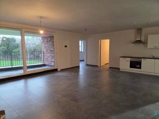 <p><span><strong>Ruim appartement van 116 m² met 3 slaapkamers, groot overdekt terras en 2 autostaanplaatsen.</strong></span></p>
<p>Dit ruime appartement op de eerste verdieping combineert modern comfort met een slimme, praktische indeling. Bij binnenkomst komt u in de inkomhal, die de twee kleinere doch volwaardige slaapkamers aan de voorzijde verbindt, toegang biedt tot de leefruimte, de badkamer en tevens het gastentoilet herbergt. De badkamer is voorzien van een badkamermeubel met dubbele wastafel, een aparte douchecabine en voldoende vrije ruimte voor extra comfort.</p>
<p>De open keuken, netjes langs één wand geplaatst en volledig uitgerust met moderne toestellen zoals een inductiekookplaat, koelkast met vriesvak en vaatwasser, aangevuld met voldoende opbergruimte voor al uw keukengerei, gaat naadloos over in de lichtrijke leefruimte, waar grote ramen een prachtig groen uitzicht bieden en een open, aangename sfeer creëren.</p>
<p>Het appartement beschikt verder over een ruime hoofdslaapkamer. <br /><br />De grote berging is praktisch ingericht met de aansluiting voor wasmachine en droogkast, en herbergt tevens de warmtepomp. Vanuit de leefruimte en keuken heeft u toegang tot het overdekte terras van 20 m², perfect om in alle seizoenen van het groene uitzicht te genieten.<br /><br />Het appartement beschikt over twee autostaanplaatsen binnenin de residentie. De autostaanplaatsen beschikken tevens over de mogelijkheden tot het opladen van elektrische of hybride voertuigen.<br /><br /><span><strong>Huurprijs</strong></span>: €1265,00 per maand.<br /><br /><span><strong>Beschikbaarheid</strong></span>: bij oplevering (medio maart 2026).<br /><br /><span><strong>EPB in opmaak.</strong></span></p>