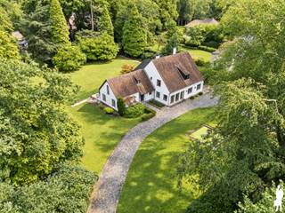 <strong>Verrassend ruime villa op prachtig perceel van ca. 4.175 m²</strong><br /><br /><strong>Via de dubbele, statige oprijlaan bereikt u deze ruime en degelijk gebouwde villa, gelegen in een uiterst rustige villawijk op een prachtig breed perceel van ca. 4.175 m². De groene omkadering en royale voortuin zorgen meteen bij het binnenrijden voor een bijzonder aangename eerste indruk en een gevoel van rust en privacy. Binnen verrast de woning met royale leefruimtes, veel lichtinval en een uitzonderlijk veelzijdige indeling. Ideaal voor een groot gezin, wonen en werken onder één dak of comfortabel wonen op het gelijkvloers.</strong><br /><br /><strong>Gelijkvloerse verdieping</strong><br />- een ruime <strong>inkomhal </strong>met gastentoilet en handenwasser<br />- een afzonderlijke kamer, geschikt als<strong> bureau, praktijk- of extra slaapkamer</strong><br />- een ruime <strong>leefruimte </strong>op natuursteen met open haard<br />- een volledig ingerichte <strong>keuken</strong> <br />- een aanpalende berging, ideaal als voorraadkamer<br />- een lichtrijke <strong>tweede</strong> <strong>woonkamer </strong>op parket met grote schuiframen en mooi contact met de tuin<br />- een achterliggend <strong>bureau/polyvalente ruimte </strong>met <strong>badkamer</strong> voorzien van lavabo, toilet en jacuzzi, alsook aansluitende <strong>dressing</strong> waardoor dit gedeelte ideaal is voor wonen op het gelijkvloers.<br />- een bijkomende <strong>polyvalente</strong> kamer, geschikt als speelkamer, tv-kamer, bureau of praktijkruimte<br />- een praktische <strong>wasplaats </strong>met aansluiting voor wasmachine en droogkast<br />- een inpandige <strong>garage</strong> met elektrische poort en spoelbak <br /><br /><strong>Eerste verdieping:</strong><br />- een centrale nachthal met afzonderlijk toilet<br />- <strong>vijf slaapkamers</strong><br />- een <strong>douchekamer </strong>met lavabo<br />- een <strong>tweede badkamer </strong>met dubbele lavabo, toilet en ligbad, met connectie aan de hoofdslaapkamer en nachthal<br />- een ruime <strong>zolderberging</strong> bereikbaar via vlizotrap<br /><br /><strong>Tuin en buitenruimte</strong><br />- een prachtig aangelegde tuin<br />- achtertuin met <strong>veel zon</strong>, veel <strong>privacy</strong> en zicht op <strong>groen</strong><br />- een verzorgd <strong>terras</strong>, volledig opnieuw aangelegd in 2024<br />- twee <strong>tuinbergingen</strong> als extra bergruimte<br />- <strong>oprijlaan met camerabeveiliging en dubbele poorten.</strong><br /><br /><strong>Bijzonderheden</strong><br />- een verrassend <strong>ruime </strong>en <strong>veelzijdige </strong>woning<br />- tal van <strong>mogelijkheden</strong> voor een groot gezin,<strong> kangoeroewonen</strong>,<strong> praktijk of kantoor aan huis </strong>en<strong> wonen op het gelijkvloers</strong><br />- zeer <strong>degelijke</strong> <strong>constructie </strong>en <strong>goed onderhouden</strong><br />- recente <strong>buitenschilderwerken</strong> in 2024<br />- verwarming op <strong>aardgas </strong>d.m.v. radiatoren<br />- <strong>videofonie</strong> en <strong>alarmsysteem</strong><br /><br /><strong>Een solide en bijzonder ruime villa op een uitzonderlijk perceel, met alle mogelijkheden om wonen, werken en ontspannen harmonieus te combineren.</strong>
