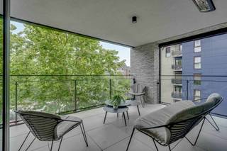 <p>Dit luxe appartement in Genk centrum met 2 slaapkamers en een ruim terras combineert hoogwaardige afwerking met instapklaar wooncomfort. Gelegen op de derde verdieping in de Kapelstraat woon je hier centraal, met winkels, horeca en het station op wandelafstand.<br /></p><p>Bij het binnenkomen valt meteen de lichtrijke leefruimte op. Grote raampartijen zorgen voor een overvloed aan natuurlijk licht en creëren een open en aangename sfeer. De leefruimte sluit naadloos aan op de open keuken, die uitgerust is met kwalitatieve toestellen en afgewerkt is met duurzame materialen. Het geheel vormt een strak en tijdloos interieur, versterkt door maatkasten die doorheen het appartement terugkomen.</p><p>Vanuit de leefruimte heb je toegang tot het ruime terras, waar je kan genieten van een groen uitzicht en een rustige buitenbeleving midden in de stad.<br /></p><p>Het appartement beschikt over twee slaapkamers, waarvan één momenteel ingericht is als een stijlvolle dressing. Deze ruimte kan eenvoudig opnieuw als slaapkamer worden gebruikt. De moderne badkamer is functioneel en verzorgd afgewerkt. Dankzij de ingebouwde kasten geniet je overal van optimaal gebruik van de ruimte en extra comfort.<br /></p><p>Een bijkomende troef is de uitzonderlijk ruime kelderberging, die veel opslagmogelijkheden biedt. Daarnaast beschikt het appartement over een ondergrondse garage met laadpunt, wat bijdraagt aan het gebruiksgemak en de toekomstgerichtheid van de woning.</p><p>Het appartement wordt volledig gemeubileerd verkocht, inclusief designmeubilair en een zorgvuldig samengesteld interieur. Dit maakt het een ideale keuze voor wie zonder zorgen wil verhuizen en meteen wil genieten van een stijlvolle woonomgeving.</p><p>De ligging is een absolute meerwaarde, met alle voorzieningen binnen handbereik en een vlotte bereikbaarheid. Dit maakt het appartement geschikt als eigen woonst of als investering.<br /></p><p>Ben je op zoek naar een instapklaar en luxueus appartement in Genk? Neem contact op en plan je bezoek.</p>
