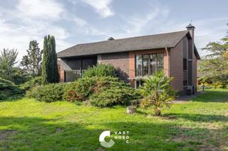 <p><strong><span>Karakteristieke woning met dubbele garage op een ruim perceel van 46 are 50 ca</span></strong></p>
<p><span>Deze karakteristieke woning uit 1964 is gelegen in een landelijke omgeving, op een steenworp van de Nederlandse grens. De woning bevindt zich op een ruim en volledig omheind perceel van maar liefst 46 are 50 ca, waar rust, privacy en ruimte centraal staan.</span></p>
<p><span>De woning werd gebouwd met duurzame en degelijke materialen en beschikt over een praktische split-levelindeling. Op het gelijkvloers bevinden zich een ruime inkomhal, een lichtrijke woon- en eetkamer, een ruime keuken en een multifunctionele bureauruimte. Op de verdieping zijn er drie ruime slaapkamers. Daarnaast beschikt de woning over een kelderverdieping met verschillende bergruimtes en sanitaire voorzieningen.</span></p>
<p><span>Een absolute meerwaarde zijn de ruime zolder van 131 m² boven de woning en de vrijstaande dubbele garage met een bijkomende zolderruimte van 51 m². Deze ruimtes bieden tal van mogelijkheden voor opslag of een verdere invulling naar eigen behoeften.</span></p>
<p><span>Ook buiten heeft deze eigendom heel wat te bieden. De tuin is aangelegd met gras- en tuinperken en een kleine vijver. Het volledige perceel is omheind met smeedwerk en toegankelijk via een voetgangerspoortje en een elektrische schuifpoort.</span></p>
<p><strong><span>Indeling:</span></strong></p>
<p><strong><span>Gelijkvloers:</span></strong></p>
<ul>
<li>
<p><span>Ruime inkomhal</span></p>
</li>
<li>
<p><span>Lichtrijke woon- en eetkamer</span></p>
</li>
<li>
<p><span>Ruime keuken met zicht op de tuin</span></p>
</li>
<li>
<p><span>Achterinkomhal </span></p>
</li>
<li>
<p><span>Bureauruimte naast de inkomhal</span></p>
</li>
</ul>
<p><strong><span>1ste verdieping:</span></strong></p>
<ul>
<li>
<p><span>Nachthal</span></p>
</li>
<li>
<p><span>3 ruime slaapkamers</span></p>
</li>
</ul>
<p><strong><span>Kelderverdieping:</span></strong></p>
<ul>
<li>
<p><span>Badkamer met douche en toilet</span></p>
</li>
<li>
<p><span>Apart toilet<br /></span></p>
</li>
<li><span>Bergruimte</span></li>
<li>
<p><span>Technische ruimte met verwarmingsketel</span></p>
</li>
<li>
<p><span>Rechtstreekse toegang naar buiten</span></p>
</li>
</ul>
<p><strong><span>Zolder:</span></strong></p>
<ul>
<li>
<p><span>Verder in te richten zolderruimte van 131 m²</span></p>
</li>
</ul>
<p><strong><span>Buitenruimte:</span></strong></p>
<ul>
<li>
<p><span>Tuin met gras- en tuinperken en een kleine vijver</span></p>
</li>
<li>
<p><span>Vrijstaande dubbele garage met zolderruimte van 51 m²</span></p>
</li>
<li><span>Achterzijde van garage is een stal voorzien</span></li>
<li>
<p><span>Volledig omheind perceel met smeedwerk</span></p>
</li>
<li>
<p><span>Elektrische schuifpoort en aparte toegangspoort</span></p>
</li>
</ul>
<p><strong><span>Troeven:</span></strong></p>
<ul>
<li>
<p><span>Rustige, landelijke ligging nabij de Nederlandse grens</span></p>
</li>
<li>
<p><span>Uitzonderlijk ruim perceel van 46 are 50 ca</span></p>
</li>
<li>
<p><span>Drie ruime slaapkamers en een bureauruimte</span></p>
</li>
<li>
<p><span>Maar liefst 182 m² aan bijkomende zolderruimte</span></p>
</li>
<li>
<p><span>Tal van mogelijkheden voor wie op zoek is naar ruimte, flexibiliteit en privacy<br /><br /></span></p>
</li>
</ul>
<p><span>Ben jij op zoek naar een karaktervolle woning met veel ruimte en potentieel? Neem contact met ons op voor meer informatie of een bezichtiging. We helpen je graag verder!</span></p>