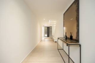 <p><span>Aan het einde van de rustige, doodlopende Pruimelaarstraat, ligt deze luxueus afgewerkte woning (2019) met een verzorgd aangelegde tuin, camera’s, alu antraciet buitenschrijnwerk (Reynaers), wachtleiding voor oplaadpunt, alu poort, geïntegreerde pakketbrievenbus, maatkasten, etc. De gelijkvloerse verdieping is voorzien van hoogwaardige designbinnendeuren van Anyway Doors. De EPC-score van 89 (Label A) werd bereikt door integratie van: algemene vloerverwarming, condensatieketel, 18 zonnepanelen en dikke isolatielagen. De ruime leefruimte beschikt over een tv-meubel (maatwerk), geïntegreerde gashaard (M-Design), afstandsbediende elektrische binnenlamellen (Somfy), ingebouwde speakers, grote alu schuiframen (Reynaers), gepolierde betonvloer en plafondhoge deuren (Nordex). Let in de aangelegde tuin met veel privacy op de prijzige overdekte terrasconstructie (Brustor), de robotmaaier, het bijgebouw en de tuinverlichting (app). In de luxueuze keuken (Grando), spotten we veel (verborgen) bergruimte, Dekton werkbladen, een groot kookeiland (6 zitplaatsen), Miele toestellen (oven, microgolfoven, koffiemachine, koelkast, diepvries), plus een kookplaat met geïntegreerde afzuiging. Opbergruimte is beschikbaar in een wasplaats, een droge kelder en een technische ruimte. In de toiletten is zelfs de rolhouder geïntegreerd in de muur. De luxe-badkamer is groot genoeg voor de inloopdouche (stalen deur) en het dubbele badkamermeubel (maatwerk). Alle kamers bieden plaats voor een dubbel bed. De exclusieve handgemaakte trap van Genico met Corian afwerking en geïntegreerde LED-verlichting, geeft aan van welk hoog niveau de afwerking wel is.</span></p>