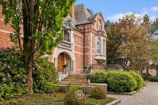 Deze prachtige villa, gebouwd in 1983 door gerenommeerd vastgoedontwerper M. Raymaekers, straalt bij binnenkomst direct charme en klasse uit dankzij het gebruik van authentieke materialen en originele elementen. Het imposante pand is doordrenkt met prachtig houtsnijwerk, inlegwerk en gebogen plafonds, waardoor een unieke sfeer ontstaat. Voorzien van luxe voorzieningen zoals een lift, een indrukwekkende gevel, airconditioning en tennisveld.<br /><br />Gunstig gelegen in Hasselt, biedt deze woning niet alleen nabijheid tot het stadscentrum maar ook een centrale ligging ten opzichte van de E313 snelweg.<br /><br />Bij het betreden van de begane grond valt meteen de royale inkomhal op, waar uw aandacht wordt getrokken door het bijzondere inlegwerk in de natuurstenen vloer en de hoge plafonds met ornamenten en sierlijsten. Op deze verdieping bevinden zich tevens de ouderlijke slaapkamer met toegang tot het terras, een luxe marmeren badkamer en twee andere slaapkamers met eigen badkamerfaciliteiten.<br /><br />De eerste verdieping verwelkomt u met een gezellige leefruimte, voorzien van een open haard, een eetkamer en een volledig uitgeruste keuken. Op de tweede verdieping vindt u nog twee ruime slaapkamers of hobbyruimtes.<br /><br />De kelder, op tuinniveau, biedt ruimte aan grote inpandige garages met automatische poorten en diverse praktische bergruimtes.<br /><br />De parktuin is een oase van rust en groen, met een tennisbaan, grote vijver en verschillende gezellige terrassen. Achteraan het perceel staat een verzorgd tuinhuis met terras, waar u kunt genieten van het uitzicht op zowel de waterpartij als het tennisveld. De landelijke en rustige ligging aan de rand van de stad maken het plaatje af!