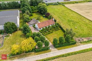 Landhuis bestaande uit inkomhal, zeer ruime living met open haard, eetplaats, ingerichte keuken met ontbijthoek, gelijkvloerse slaapkamer met badkamer, ruim bureel (of hobbykamer), wasplaats en berging. 3 Slaapkamers, dressing en badkamer op verdiep. Tuin met bijgebouw (bar) en ruime garage/opslagruimte. 14 zonnepanelen aanwezig. Opp. 4.190m²<br />