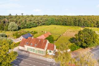Pal tegenover het prachtige Bulskampveld, op een steenworp van de op- en afrit van Beernem, bevindt zich deze uitzonderlijk charmante, gerenoveerde hoeve op een perceel van ca. 2 hectare. Een zeldzame combinatie van landelijke rust, natuurbeleving en een uitstekende bereikbaarheid.<br /><br />De authentieke hoofdwoning (358 m²) ademt sfeer en karakter en beschikt over maar liefst 7 slaapkamers, elk met een eigen bad- of douchekamer en toilet. De vernieuwde leefkeuken vormt het warme hart van de woning en sluit naadloos aan op de gezellige leefruimte, waar authentieke elementen en hedendaags wooncomfort elkaar perfect aanvullen. De stijlvolle wellnessruimte met een binnenzwembad in glasmozaïek, sauna en douche nodigt uit om het hele jaar door in alle privacy te ontspannen.<br /><br />Verder beschikt de eigendom over een dubbele garage met tuinberging en een vergund bijgebouw van 193 m² als vakantiewoning. Deze omvat een wasplaats, hyper geïnstalleerde keuken, ruime leefruimte met prachtig zicht op de tuin en de weiden, en een luxueuze suite met slaapkamer, inloopdressing en ensuite badkamer. Ideaal als opbrengsteigendom, gastenverblijf of kangoeroewoning.<br /><br />Voor paarden- en dierenliefhebbers is dit een unieke plek, met buitenpiste, 5 paardenstallen, wasplaats, voederruimte, twee schuilhokken én een rechtstreekse toegang vanuit de weide naar de ruiterpaden van het Bulskampveld. Een uitzonderlijke eigendom waar authenticiteit, comfort en natuur elkaar moeiteloos vinden.