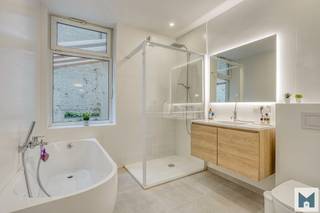 Ontdek dit charmante en praktisch ingedeelde gelijkvloerse appartement van maar liefst 131m² op een toplocatie, vlakbij het groene Park van Laken.<br />Ideaal voor wie comfortabel en centraal wil wonen met alle voorzieningen binnen handbereik.<br /><br />Het karaktervolle appartement beschikt over een inkom, een gezellige leefruimte, praktische keuken met berging, 2 volwaardige slaapkamers en vernieuwde badkamer met ligbad en douche. Extra troeven zijn de charmante sierlijsten, hoge plafonds, authentieke deuren en houten vloeren.<br />Op de benedenverdieping bevindt zich nog een 2e badkamer met douche en een extra ruimte van 22,50m² die perfect kan dienen als bureau, dressing, hobbyruimte of extra bergruimte. Achteraan geniet je van een aangename, privatieve stadskoer van 13,50m² waar u in alle rust kan genieten van een gezellig moment buiten.<br />In de gemeenschappelijke kelder is er bovendien nog een privéberging, handig voor extra opslag.<br /><br />De ligging is een absolute troef: centraal gelegen en in de onmiddellijke nabijheid van openbaar vervoer, winkels en scholen. <br />U geniet hier van een uitstekende bereikbaarheid én een groene omgeving nabij het Park van Laken. Kortom een appartement met veel troeven. Mis deze kans niet! <br /><br />EPC: 320 kWh/m²/j en F label met UC: 20180408-0000525399-01-5<br />Voor meer inlichtingen of een vrijblijvend bezoek kan u contact opnemen met Marik op het nummer 052/21.65.51 of mailen naar info@immomiddelpunt.be.