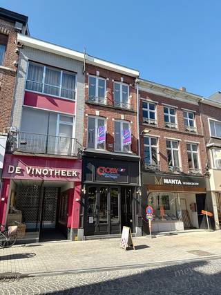 In de levendige Stapelstraat in Sint-Truiden bevindt zich dit veelzijdige handelspand met bovenliggende woonst. De centrale ligging tussen winkels, horeca en andere diensten zorgt voor een goede commerciële zichtbaarheid en passage. Een interessante locatie voor wie een eigen zaak wil uitbouwen en wonen en werken wil combineren.<br /><br />Het pand beschikt over een totale oppervlakte van circa 148 m² volgens het EPC. Op het gelijkvloers bevindt zich een handelsruimte van circa 62 m², die vroeger dienstdeed als bakkerij. De ruimte is momenteel niet meer ingericht en biedt een neutrale basis voor een nieuwe commerciële invulling, afgestemd op uw activiteiten en wensen. De aansluitende achterruimte is praktisch voor opslag of ter ondersteuning van de handelsactiviteit.<br /><br />Het woongedeelte strekt zich uit over de bovenliggende verdiepingen en omvat een aangename leefruimte, een ingerichte keuken met toegang tot het terras, een badkamer en twee tot drie slaapkamers. Daarnaast is er een ruime zolder, die extra opslagruimte biedt of verder ingericht kan worden, mits de nodige vergunningen.<br /><br />Ook de bereikbaarheid vormt een troef. Parkeermogelijkheden, openbaar vervoer en het station van Sint-Truiden bevinden zich in de nabije omgeving, terwijl de centrale ligging zorgt voor dagelijkse voorzieningen binnen handbereik.<br /><br />De combinatie van handelsruimte en woonst maakt deze eigendom aantrekkelijk voor zelfstandigen die hun zaak en woning op één adres willen onderbrengen. Ook voor investeerders die een veelzijdig pand in het centrum van Sint-Truiden zoeken, biedt deze eigendom mogelijkheden.<br /><br />Benieuwd wat dit pand voor uw plannen kan betekenen? Contacteer Meyers Vastgoed voor meer informatie of een bezichtiging ter plaatse.