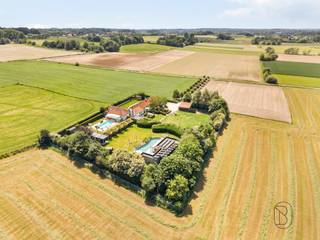 Prachtig gelegen eigendom op een uitzonderlijke locatie met adembenemende verzichten (mogelijkheid overname aandelen). Verscholen in alle rust en bereikbaar via een statige, lange toegangsdreef bevindt zich dit uitzonderlijke eigendom op een perceel van maar liefst 5.721 m². Een zeldzame locatie waar privacy, natuur en ruimte naadloos samenkomen.De unieke ligging biedt panoramische verzichten over het omliggende landschap en creëert een oase van rust, terwijl u toch geniet van een vlotte bereikbaarheid. Dit is een eigendom met karakter en vooral met een enorm toekomstpotentieel. Ideaal als B&amp;B/wellness. Dankzij de royale perceeloppervlakte en de veelzijdige mogelijkheden leent deze eigendom zich perfect voor wie op zoek is naar een exclusieve woonst, een combinatie van wonen en werken, natuur of een project waarbij ruimte en ligging centraal staan.Charmante fermette - gelijkvloers wonen, extra B&amp;B-gedeelte, wellness met sauna, en zwembad (overkapping mogelijk); extra charmant bijgebouw (voorzien van zonnepanelen) met zwemvijver, carport en tuinhuis, prachtige tuin en toegangsweg. Bent u op zoek naar een unieke locatie waar u uw eigen visie kunt realiseren? Dan is dit zonder twijfel een buitenkans.Bezoek na afspraak met IMMO BEGUIN: flore@immobeguin.be