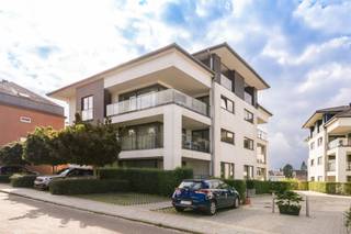 <p><span>Dit ruime en lichtrijke gemeubelde appartement van ca. 125 m² is gelegen op de eerste verdieping van een recent en uitstekend onderhouden gebouw uit 2012, aan de Drève de lInfante 19 te Waterloo. Het appartement combineert comfort, kwaliteit en een uiterst strategische ligging, recht tegenover het station van Waterloo en op korte afstand van alle voorzieningen en belangrijke invalswegen richting Brussel. Hierdoor is het bijzonder geschikt voor pendelaars, maar eveneens als comfortabele gezinswoning of waardevaste investering.</span></p><p><span>Bij het binnenkomen leidt de inkomhal naar een zeer ruime en lichtrijke woonkamer met eetgedeelte. De grote raampartijen zorgen voor een aangename natuurlijke lichtinval en een ruimtelijk gevoel. Vanuit de leefruimte heeft u rechtstreeks toegang tot het zonnige terras van maar liefst 20 m², een ideale plek om in alle rust te genieten. De volledig ingerichte keuken sluit naadloos aan op de leefruimte en biedt eveneens directe toegang tot het terras.</span></p><p><span>Via de nachthal bereikt u de twee comfortabele slaapkamers, de badkamer, een praktische berging en een aparte wasruimte, uitgerust met wasmachine en droogkast. Daarnaast beschikt het appartement over een privatieve kelder, die extra en handige opslagruimte biedt.</span></p><p><span>Het appartement is kwalitatief afgewerkt met een massieve houten parketvloer en voorzien van dubbele beglazing, wat zorgt voor een uitstekend thermisch en akoestisch comfort. Met een gunstige EPC-score B (115 kWh/m²/jaar) en een conforme elektrische installatie voldoet het bovendien aan belangrijke hedendaagse comfort- en kwaliteitsnormen.</span></p><p><span>Een overdekte parkeerplaats dient verplicht te worden aangekocht voor 28.000.</span></p><p><span>Dit instapklare appartement biedt een uitstekende combinatie van ruimte, licht, comfort, kwaliteit en bereikbaarheid en vormt zowel een aangename gezinswoning als een interessante investering.</span></p><p><span>Belangrijke informatie betreffende de foto's:</span><span> de foto's in deze advertentie zijn genomen in een appartement aan de straatzijde van het gebouw. Het te koop aangeboden appartement beschikt over </span><span>een identieke indeling en vergelijkbare afwerking</span><span>, maar is gelegen aan de </span><span>achterzijde van het gebouw</span><span>. Het appartement is bovendien </span><span>zuidwest georiënteerd</span><span>, wat zorgt voor een bijzonder aangename oriëntatie en optimale avondzon.</span></p>