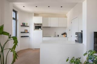 <p><span>Lichtrijk stadsappartement met maatwerk en uniek zicht aan het Mechelseplein</span></p><p><span>Wonen op een van de meest karaktervolle pleinen van Antwerpen, met de stad letterlijk aan uw voeten? Dit lichtrijke appartement aan het Mechelseplein combineert een bijzonder centrale ligging met een stijlvolle afwerking, veel maatwerk en een prachtig zicht op de Antwerpse binnenstad. De warme parketvloer, grote raampartijen en doordachte inrichting zorgen voor een aangename woonbeleving midden in het bruisende stadsleven.</span></p><p><span> </span></p><p><span>Indeling</span></p><p><span>U komt binnen in de ruime en lichtrijke leefruimte, die op natuurlijke wijze werd ingedeeld in een knusse zithoek en een gezellige eethoek. De grote raampartijen zorgen voor veel natuurlijk licht en bieden een bijzonder mooi zicht over het Mechelseplein en de skyline van de Antwerpse binnenstad. Naast de leefruimte werd een maatwerk bureau geïntegreerd, waardoor ook thuiswerken hier op een stijlvolle en praktische manier een plaats krijgt. Aansluitend bevindt zich de prachtige open keuken met centraal kookeiland. De keuken biedt veel werk- en opbergruimte en is uitgerust met een inductie kookplaat, grote vaatwasser, inox spoelbak met kraan, KitchenAid combi-oven en koelkast met afzonderlijk vriesvak. Het kookeiland vormt tegelijk een mooie verbinding tussen de keuken en de leefruimte en maakt van deze ruimte het hart van het appartement. De gezellige slaapkamer werd voorzien van ruime maatwerk kasten en beschikt over een ensuite badkamer. Deze is stijlvol afgewerkt met tegels in marmerlook en uitgerust met een lavabomeubel, toilet en ruime inloop-regendouche. Bij het appartement hoort bovendien een ruime en droge privatieve kelderberging, inbegrepen in de verkoopprijs.</span></p><p><span> </span></p><p><span>Belangrijkste troeven</span></p><ul><li><span>Unieke ligging aan het Mechelseplein, midden in het centrum van Antwerpen</span></li><li><span>Prachtig zicht op het plein en de skyline van de binnenstad</span></li><li><span>Veel natuurlijke lichtinval dankzij de grote raampartijen</span></li><li><span>Warme parketvloer doorheen het appartement</span></li><li><span>Open keuken met kookeiland en kwalitatieve toestellen</span></li><li><span>Maatwerkbureau, ideaal voor thuiswerk</span></li><li><span>Slaapkamer met maatwerkkasten en ensuite badkamer</span></li><li><span>Ruime en droge privatieve kelderberging inbegrepen</span></li><li><span>EPC-label B</span></li><li><span>Elektrische installatie conform het AREI</span></li><li><span>Gemeenschappelijke fietsenstalling</span></li></ul><p><span> </span></p><p><span>Algemene informatie</span></p><p><span>De gemeenschappelijke kosten bedragen € 79,20 per maand en omvatten onder meer het onderhoud en verbruik van de gemeenschappelijke delen, de syndicus en de blokpolis.</span></p><p><span>Het appartement beschikt over individuele meters voor elektriciteit, water en gas.</span></p><ul><li><span>EPC: label B</span></li><li><span>Elektrische keuring: conform het AREI</span></li><li><span>Asbestattest: asbestveilig</span></li></ul><p><span> </span></p><p><span>Het gebouw</span></p><p><span>Het appartement bevindt zich in een kleinschalig gebouw bestaande uit een handelsruimte op het gelijkvloers en zes appartementen verdeeld over de vier bovenliggende verdiepingen.</span></p><p><span>Op het gelijkvloers is een gemeenschappelijke fietsenstalling aanwezig. Het gebouw beschikt eveneens over parlofonie.</span></p><p><span> </span></p><p><span>Ligging</span></p><p><span>Het Mechelseplein is zonder twijfel een van de meest levendige en karaktervolle plekken in de Antwerpse binnenstad. Hier woont u midden in de stad, omringd door gezellige cafés, restaurants, cultuur en historische architectuur.</span></p><p><span>Op wandelafstand bevinden zich onder meer de Botanische Tuin, het Theaterplein, de Leopoldstraat, de Nationalestraat en de historische binnenstad. Ook winkels, supermarkten en openbaar vervoer bevinden zich in de onmiddellijke omgeving.</span></p><p><span>Ondanks de uitgesproken stadsligging biedt het appartement dankzij zijn ligging boven het plein een bijzonder open gevoel en een knap uitzicht over de Antwerpse skyline. Een ideale uitvalsbasis voor wie volop van het stadsleven wil genieten zonder in te boeten aan wooncomfort.</span></p><p><span> </span></p><p><span> </span></p><p><span>De informatie in deze prospect is ter informatieve titel: de kandidaat-kopers moeten hun eigen zaak maken van het verkrijgen, controleren en interpreteren van deze informatie.</span></p><p><span> </span></p>