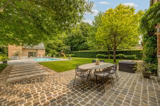 Achter een elegante houten poort, verscholen in het groen van een residentiële straat, schuilt deze charmante villa in landelijke stijl. Een...