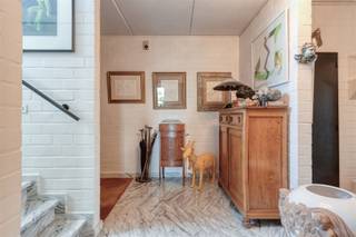 Tijdloze villa met prachtige tuin en adembenemende verzichten. Deze woning werd gebouwd in 1985 door de huidige eigenaar en steeds perfect onderhouden. Indeling: ruime inkomhal met gastentoilet, droge kelder, een zonnige living met afsluitbare zithoek, volledig ingerichte keuken met aansluitend een gezellige orangerie en een berging/wasplaats die is voorzien van ingemaakte kasten. Via de berging heb je toegang tot de ruime garage voor 2 wagens. Op de verdieping bevinden zich 3 ruime slaapkamers, een berging en een badkamer die is uitgerust met een dubbele lavabo, douche, ligbad en extra toilet. Eén van de slaapkamers en de badkamer hebben toegang tot het grote dakterras. Mooi aangelegde, zuid-west geörienteerde tuin met een groot terras, 2 grote vijvers en een ruim tuinhuis. Het epc vermeld in de publiciteit is de score nadat er een investering van € 10.000 (volgens offerte) wordt gedaan om de elektrische verwarming aan te passen naar een warmtepomp systeem.