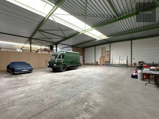 Magazijn / opslagplaats van 465m²<br />Vooraan bevindt zich een geautomatiseerde poort van 4m20H op 3m50B met erachter een gezamelijk laad/losplaats.<br />Achteraan de opslagplaats van 20m bij 23m met <br />- geïsoleerd dak met lichtstraat<br />- vrije hoogte 5m65<br />- gepolierde betonvloer<br />- verlichting aanwezig<br />- elektriciteit 380V/160A<br />- warmeluchtblazer op mazout<br />Vrij vanaf 01/12/2025<br />