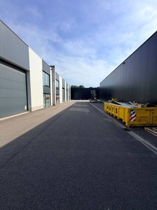Gelegen langs het kanaal Dessel-Schoten. <br /><br />Automatische inrijpoort 4.50m hoogte x 4.00m breedte. <br />Vrije plafondhoogte : 7.00m<br />Binnenafmetingen 14,86m breed en een diepte van 24,83m <br />Met hout is de binneninrichting afgewerkt tot een kantoor/refter met een verdieping voorzien van 2 toiletten.<br /><br />Bijzonderheden: <br />- Brandmuren tussen de loodsen voorzien <br />- Rookluik en brandslang aanwezig <br />- Toiletten<br />- Lichtstraat centraal in de daken <br />- 2 parkeerplaatsen inbegrepen<br /><br />Voor meer info of een bezoek kan je Bart bellen op het nummer 0474/344.300