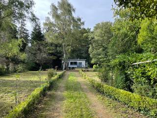 Centraal gelegen doch goed weggestopt temidden de natuur, op het door de bossen slingerende deel van de met grind bedekte Hamerstraat waant men zich in de Ardennen. De prachtige tuin van maar liefst 3530m² is omheind, metalen inkompoort die toegang geeft tot de private oprit is voorzien van videofoon. De woning voorziet in o.a. inkom met gastentoilet, keuken met aanpalende berging, ruime lichtrijke leefruimte, één slaapkamer, badkamer, wasplaats/berging, garage en ruime bijgebouwen/atelier. De vakantiewoning is volledig onderkelderd.
Kom dit pareltje ontdekken en laat u fantasie de vrije loop.
Dit betreft een te renoveren pand.
Info/plaatsbezoek 0473/245102 of info@vandenvonder-decat.be.