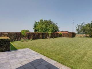 Het wordt steeds zeldzamer om een solide gebouwde villa op een royaal perceel van 15are te vinden die bovendien volledig klaar is voor de toekomst. Deze uitzonderlijk goed onderhouden villa combineert een tijdloze, kwalitatieve bouw met hedendaags wooncomfort en een indrukwekkend pakket aan energiezuinige technieken. Met een bewoonbare oppervlakte van ca. 275 m², vijf slaapkamers, twee luxueuze badkamers en een EPC-score van slechts 129 kWh/m² per jaar is deze villa de ideale gezinswoning voor wie op zoek is naar ruimte, comfort en duurzaamheid.<br /><br />Via de ruime inkomhal betreedt u de woning. Hier bevinden zich drie slaapkamers, waarvan één momenteel is ingericht als bureel. Verder vindt u hier een gastentoilet, een stijlvolle en functionele keuken en een bijzonder ruime, lichtrijke leefruimte waar grote raampartijen zorgen voor een aangename lichtinval. Vanuit de woonkamer heeft u rechtstreeks toegang tot het mooie balkonterras aan de voorzijde van de woning met zicht over het Raspaillebos. De hoogwaardige badkamer op het gelijkvloers straalt luxe uit en is uitgerust met een ligbad, een ruime inloopdouche en een dubbele wastafel. De bovenverdieping omvat nog twee ruime slaapkamers en een tweede badkamer. Ideaal als aparte verdieping voor kinderen, gasten of een inwonend familielid. De kelderverdieping biedt tal van praktische mogelijkheden en omvat een garage, een technische ruimte en voldoende opbergruimte. Ook buiten heeft deze eigendom heel wat te bieden. De prachtig aangelegde tuin vormt een groene oase waar u in alle rust kunt genieten van het buitenleven. Het ruime terras nodigt uit tot gezellige zomeravonden met familie en vrienden. Daarnaast beschikt de woning over een gemetselde berging die mooi aansluit op de woning én een afzonderlijke houten tuinberging achteraan het perceel. Bovendien is achteraan het landelijk zicht over de velden van onschatbare waarde.<br /><br />Troeven:<br />Perceel van 15are en straatbreedte van 25m<br />Ca. 275 m² bewoonbare oppervlakte<br />5 slaapkamers<br />2 stijlvolle badkamers<br />Ruime en lichtrijke leefruimte<br />Balkonterras aan de voorzijde<br />Grote aangelegde tuin met ruim zonneterras<br />Energiezuinig (EPC: 129 kWh/m² per jaar)<br />24 zonnepanelen met thuisbatterij<br />Zonneboiler<br />Nieuwe gascondensatieketel<br />Regenwaterput<br />Lucht-luchtairco's in alle slaapkamers<br />Elektrische rolluiken<br />Elektrische zonnewering over volledige achterterras<br />Laadpaal voor elektrische wagen<br />Elektriciteit conform<br />Asbestveilig