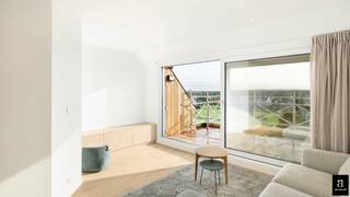 <p>This beautifully renovated penthouse is located on the prestigious Kustlaan and combines luxurious comfort with breathtaking views over Le Zoute.</p>
<p>Upon entering, the bright living space immediately captures attention, seamlessly integrating with an open, fully equipped kitchen. The kitchen features a dishwasher, a combination oven, and a spacious refrigerator with a freezer compartment. Thanks to the large windows, the living room enjoys an abundance of natural light and offers a panoramic view of the surroundings. From this space, there is direct access to the spacious and sunny terrace, which, due to its ideal orientation, benefits from sunlight throughout the day, both on the terrace and inside the apartment.</p>
<p>On the ground floor, there is also a guest toilet and a large storage room. A bedroom is also located on this level, equipped with electric shutters that allow for complete darkness. This bedroom has an ensuite shower room with a toilet and a built-in dressing area. It also provides access to a second terrace, which is bathed in the evening sun and offers a cozy outdoor space.</p>
<p>The first floor features two additional bedrooms, each with its own ensuite shower room and toilet. One of the bedrooms is spacious enough to accommodate two double beds, providing extra comfort for guests or a larger family. On this floor, there is also a second storage space with pre-installed connections for a washing machine and dryer.</p>
<p>All bedrooms are fitted with built-in wardrobes, ensuring additional storage and a sleek finish. This unique penthouse combines luxury, space, and a prime location, making it an exceptional choice for those seeking an unparalleled living experience on the coast.</p>