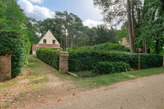 IN OPTIE!!  In een rustige, groene omgeving bevindt zich deze unieke woning, een ontwerp van de gerenommeerde Belgische architect <strong>Raymond Rombouts</strong>. Het pand staat op een mooi perceel van 1.221 m² en combineert tijdloze architectuur met een zee aan mogelijkheden.<br /><br /><strong>Indeling</strong><br />Via de oprijlaan bereikt u de woning, met achteraan een polyvalente garage van ca. 42 m².<br />De inkomhal met gastentoilet en vestiairegedeelte verwelkomt u en biedt toegang tot de eetkamer, de lichtrijke woonkamer en de keuken. Dankzij de grote raampartijen genieten zowel de woonkamer, eetkamer als keuken van overvloedig daglicht en een prachtig zicht op de tuin. Op de verdieping bevinden zich drie slaapkamers, een badkamer met douche in bad en een apart toilet.<br /><br /><strong>Bouwmogelijkheden</strong><br />Het perceel biedt bovendien interessante uitbreidingsmogelijkheden:
<ul>
	<li><span>Totale bebouwbare oppervlakte (hoofd- en bijgebouwen): max. 250 m² voor percelen tot 2.500 m²</span></li>
	<li><span>Kroonlijsthoogte: max. 7 m</span></li>
	<li><span>Totale verharde oppervlakte: max. 10% van de perceeloppervlakte, op min. 3 m van de perceelsgrenzen</span></li>
</ul>
<strong>Architectuur</strong><br />Raymond Rombouts wordt beschouwd als één van de meest toonaangevende Belgische architecten van de twintigste eeuw. Zijn ontwerpen zijn sterk geïnspireerd door de harmonieuze verhoudingen van achttiende-eeuwse landhuizen, kastelen, herenwoningen en hoeves. Hij stond bekend om zijn integriteit, passie en perfectionisme, wat resulteerde in authentieke meesterwerken die ambachtelijk vakmanschap en harmonie uitstralen.